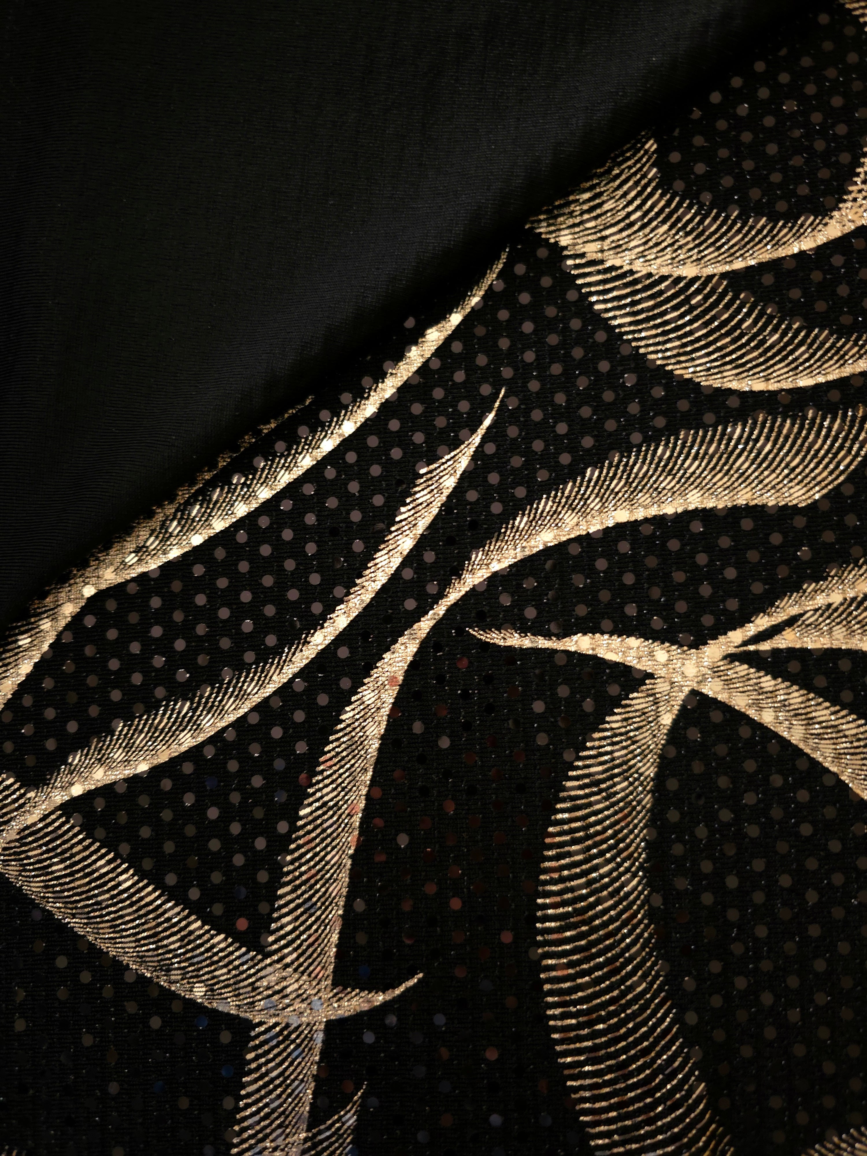 Soft Gold Abstract Ribbon sequin fabric shown in folded detail, revealing metallic highlights against the sheer black base for dance costumes, performancewear and fitted bodice accents.