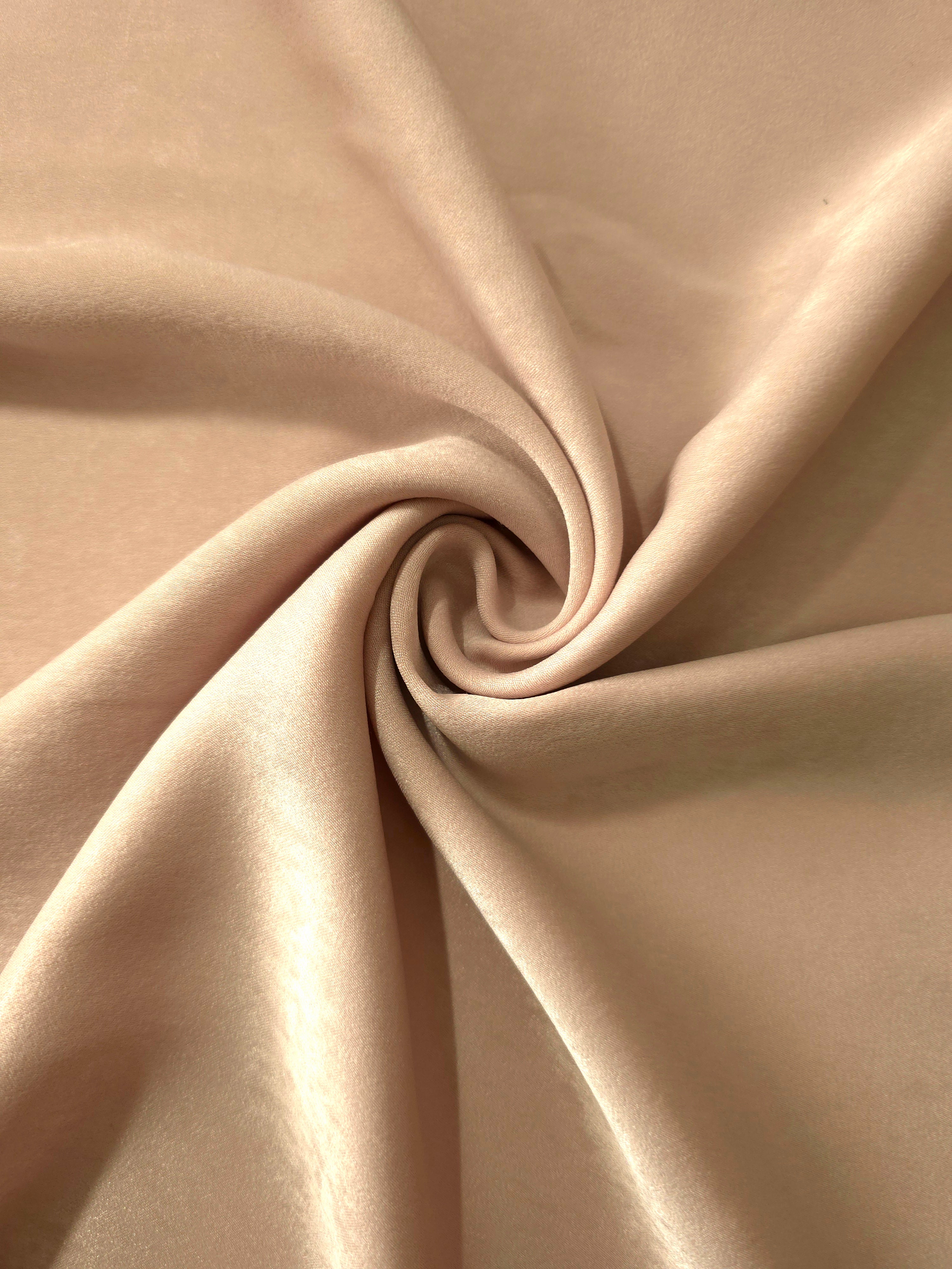 Soft folded detail of Camel Sand Milano sandwashed silky fabric highlighting its matte finish and supple hand