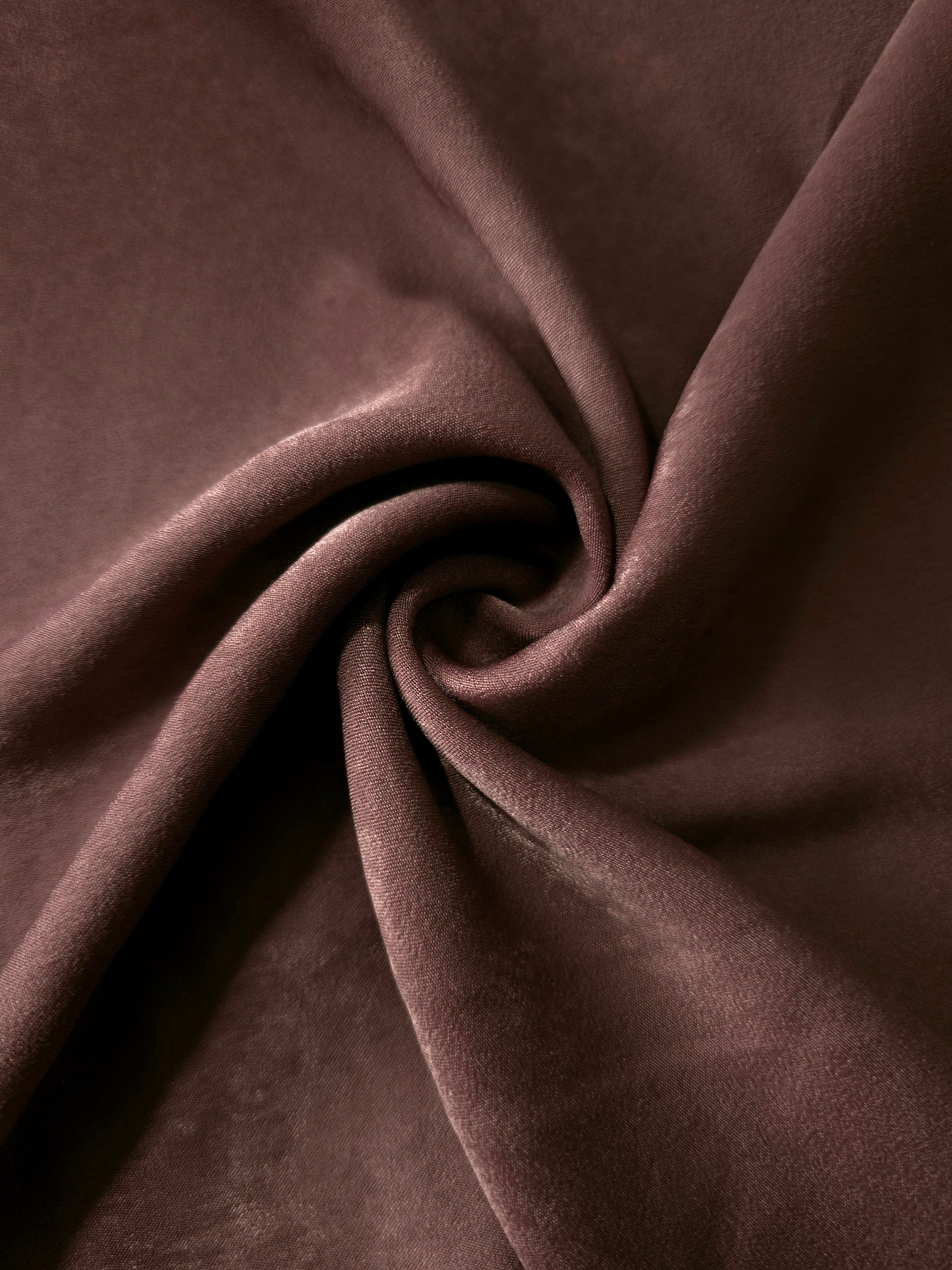 Soft folded detail of Chestnut Wine Milano sandwashed silky fabric highlighting its matte finish and supple hand