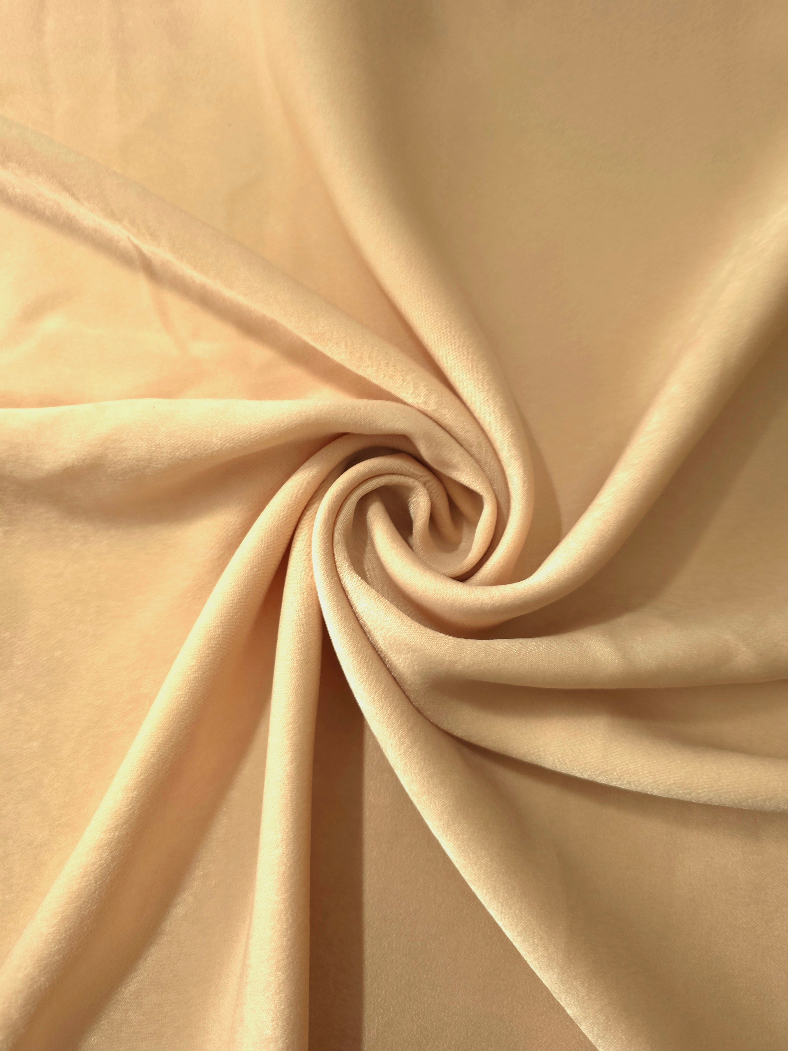 Soft folded detail of Golden Wheat Milano sandwashed silky fabric highlighting its matte finish and supple hand