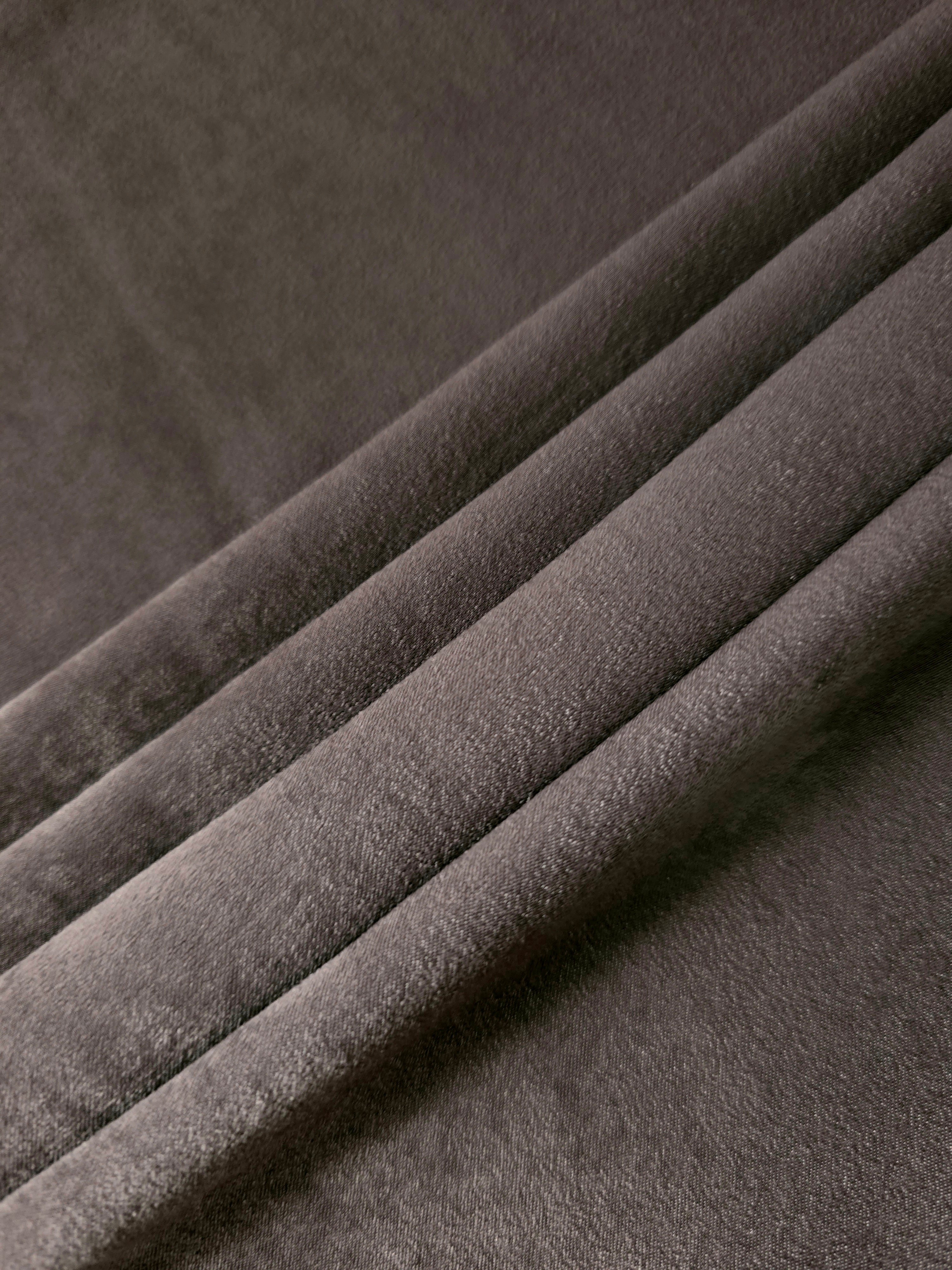 Soft folded detail of Graphite Taupe Milano sandwashed silky fabric highlighting its matte finish and supple hand