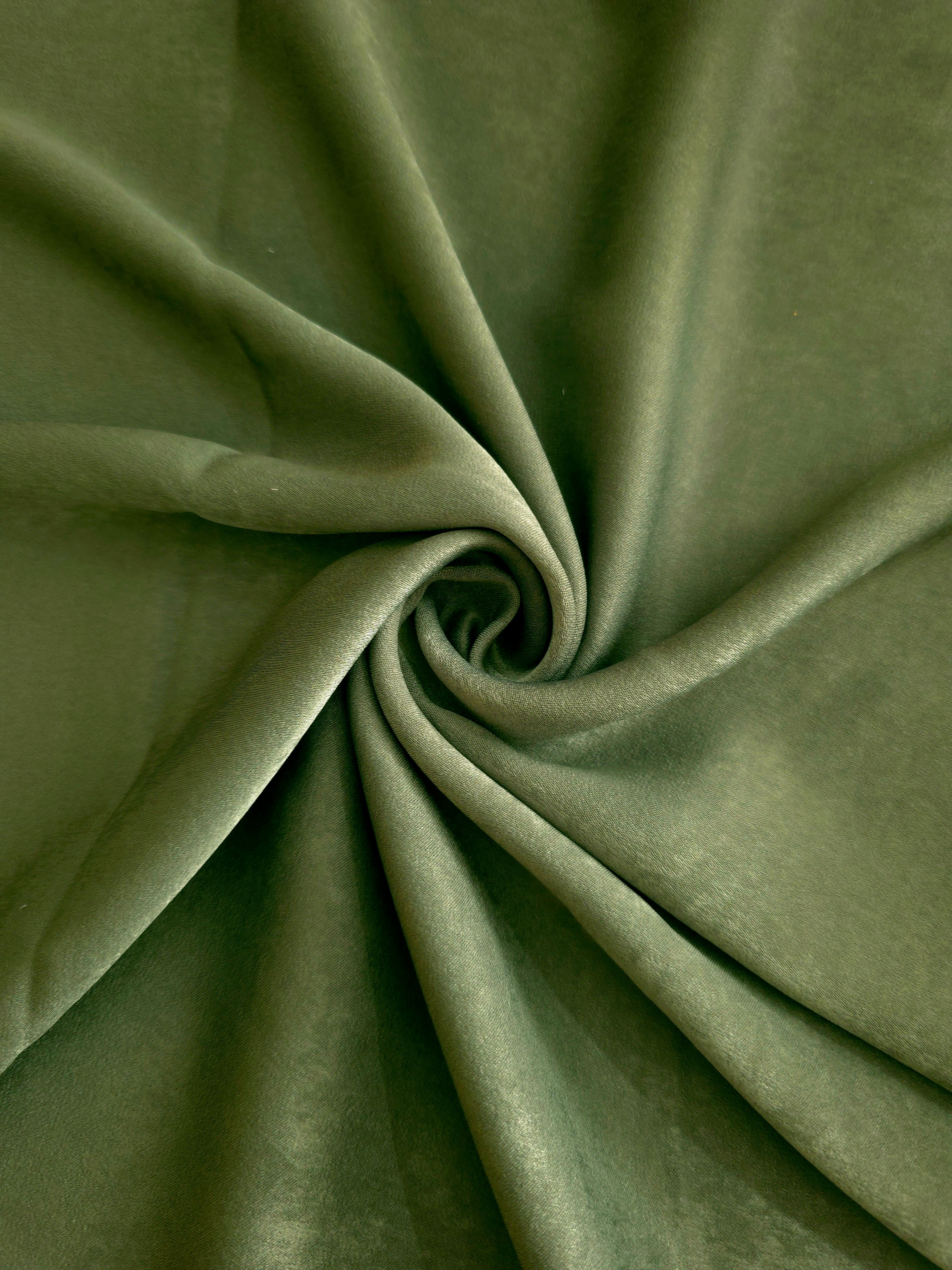 Soft folded detail of Loden Moss Milano sandwashed silky fabric highlighting its matte finish and supple hand