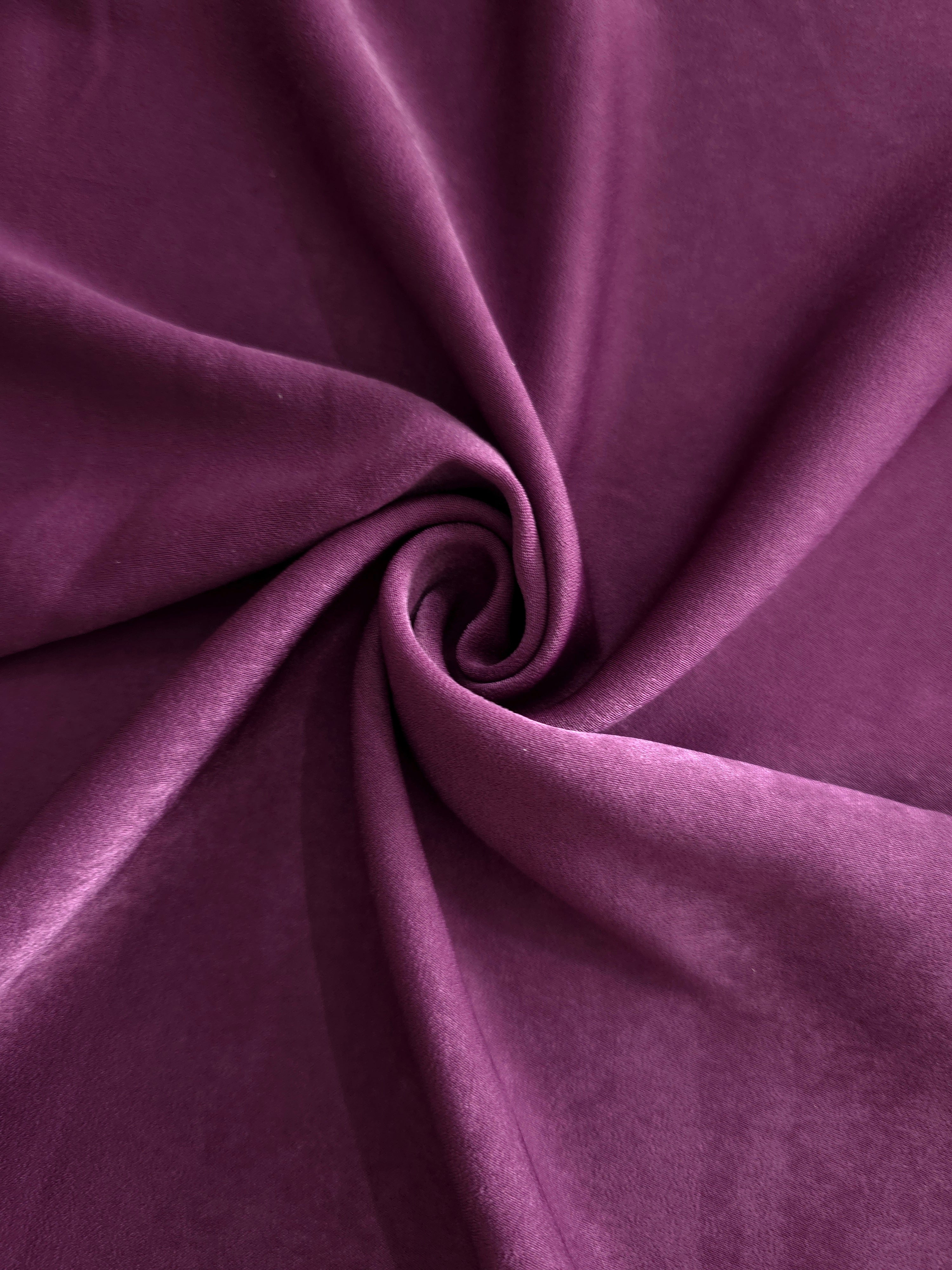 Soft folded detail of Mulberry Plum Milano sandwashed silky fabric highlighting its matte finish and supple hand