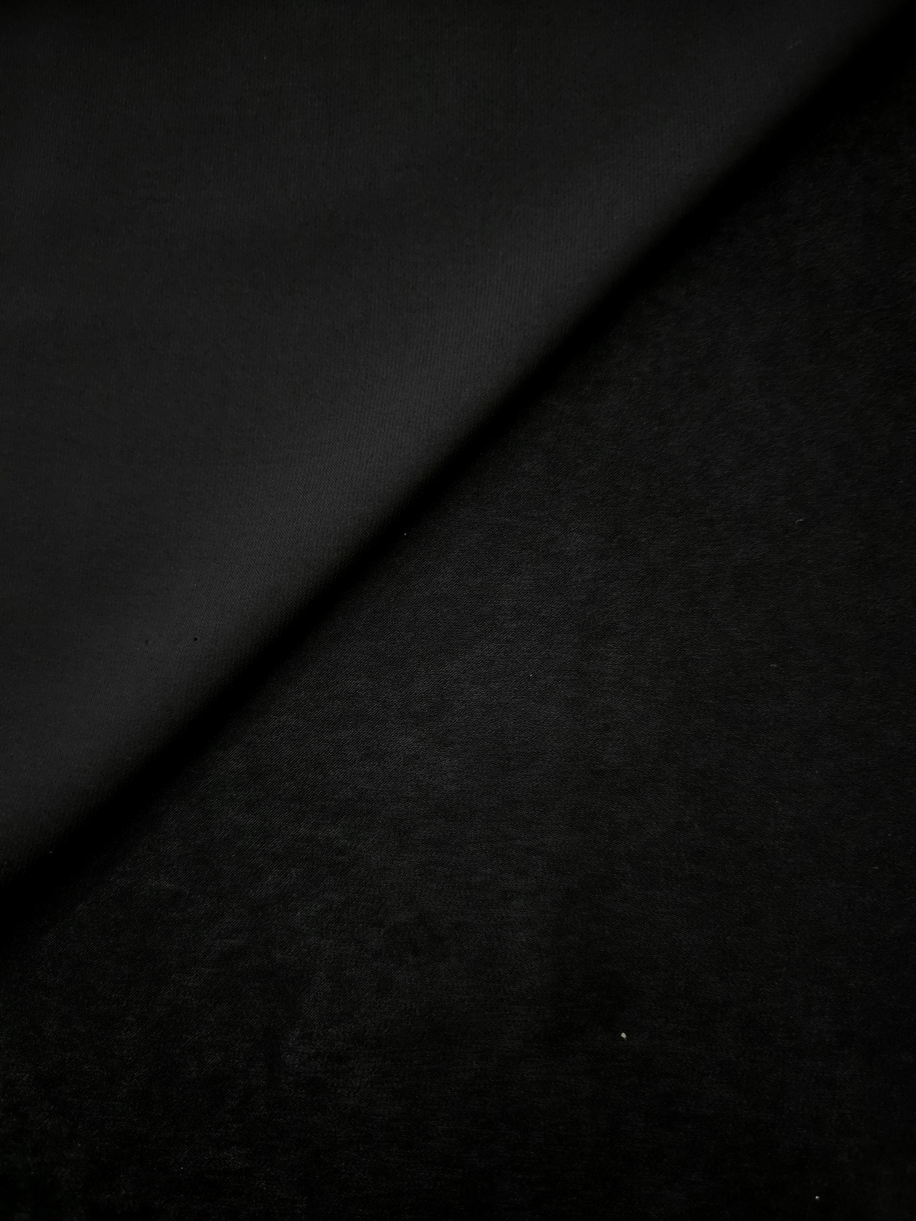 Milano matte sandwashed silky fabric in Obsidian Black, shown as a soft textile for dresses, blouses and apparel