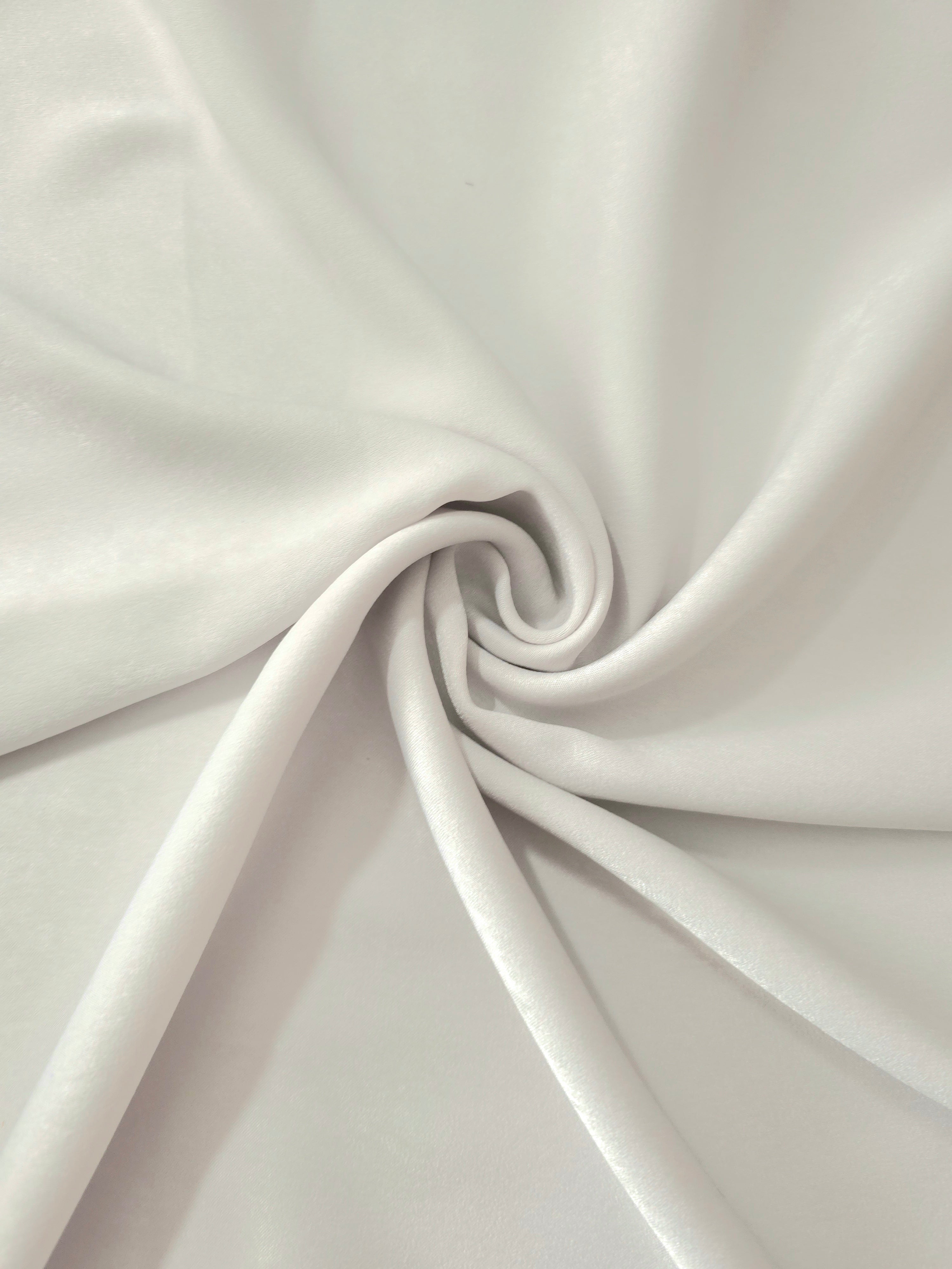 Soft folded detail of Silver Sage Milano sandwashed silky fabric highlighting its matte finish and supple hand