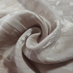 Close drape of flower brick jacquard showing fold detail and soft sheen.