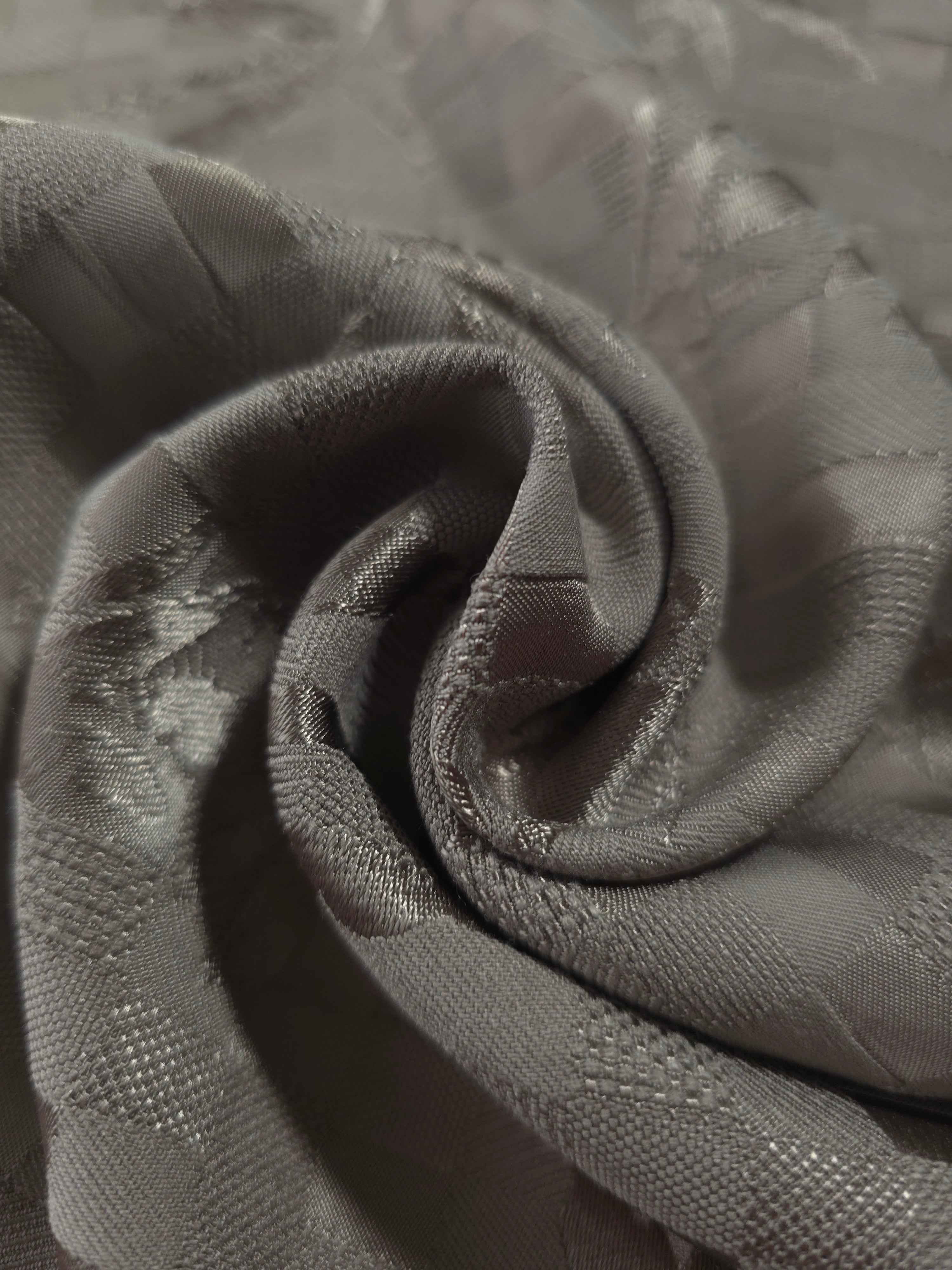 Close drape of tonal flower brick jacquard showing folds and texture.