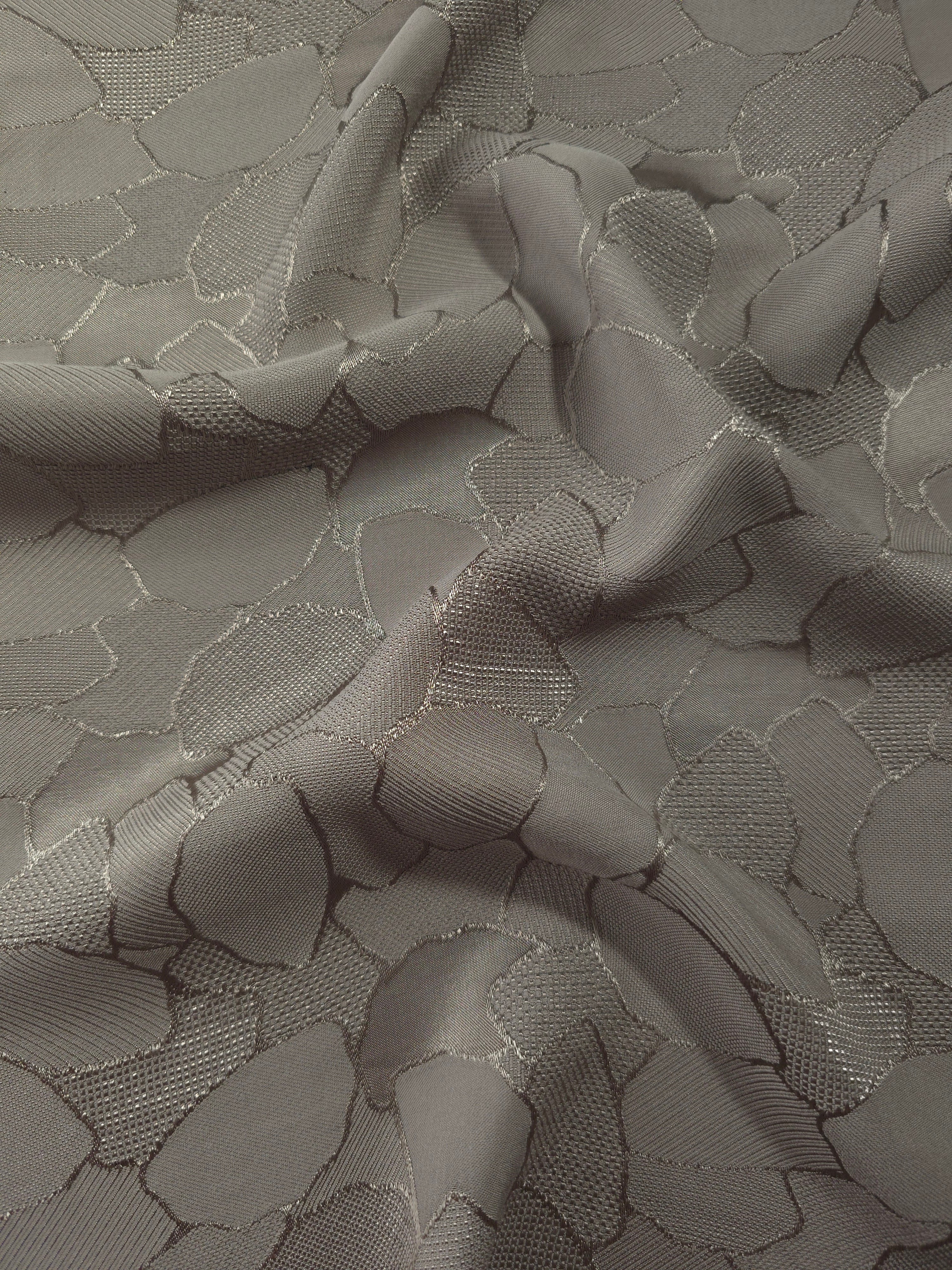 Wave fold of tonal mosaic jacquard showing satin-on-matte woven contrast.