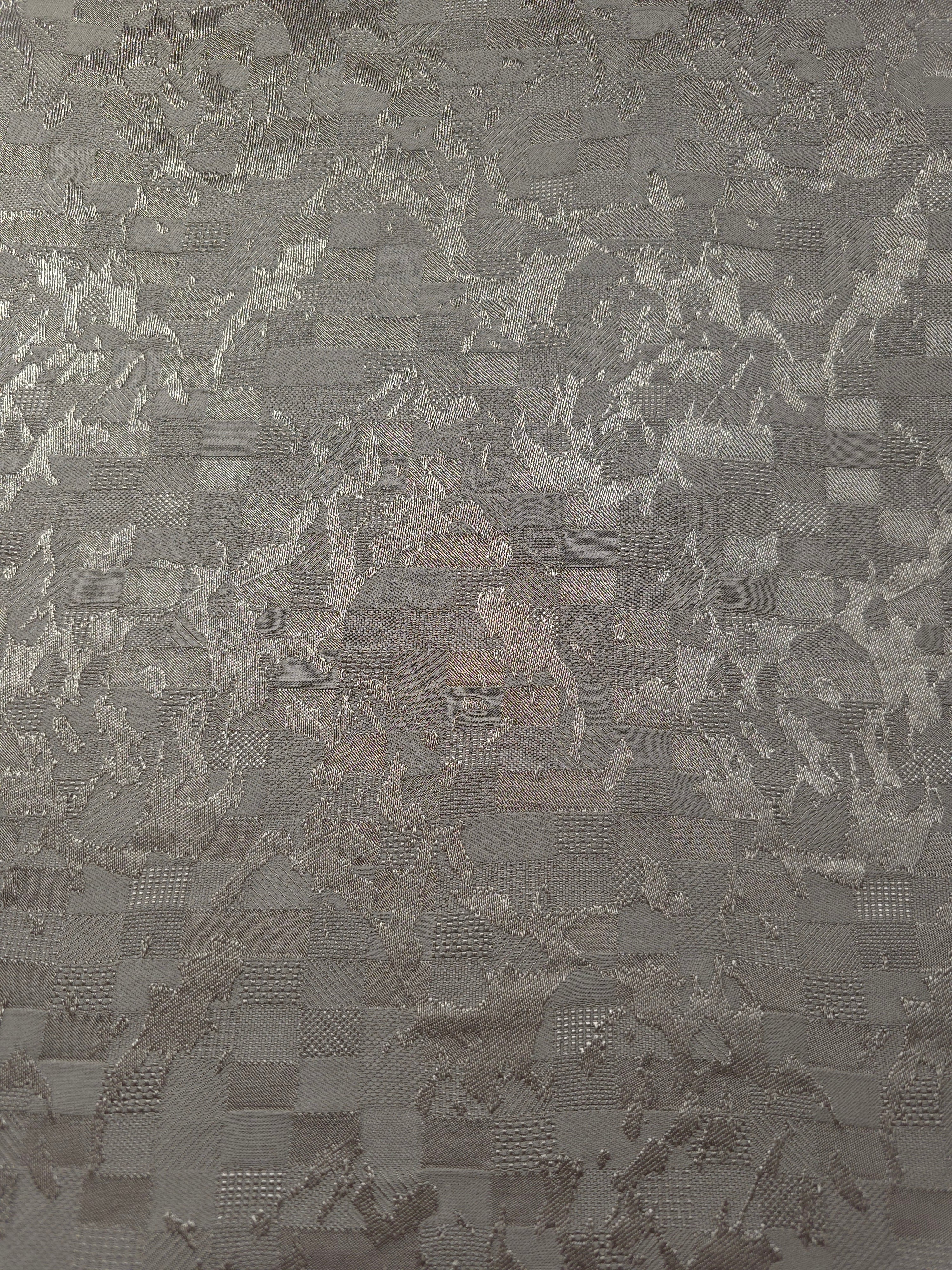 Wide view of tonal splash brick jacquard fabric for garment panels.