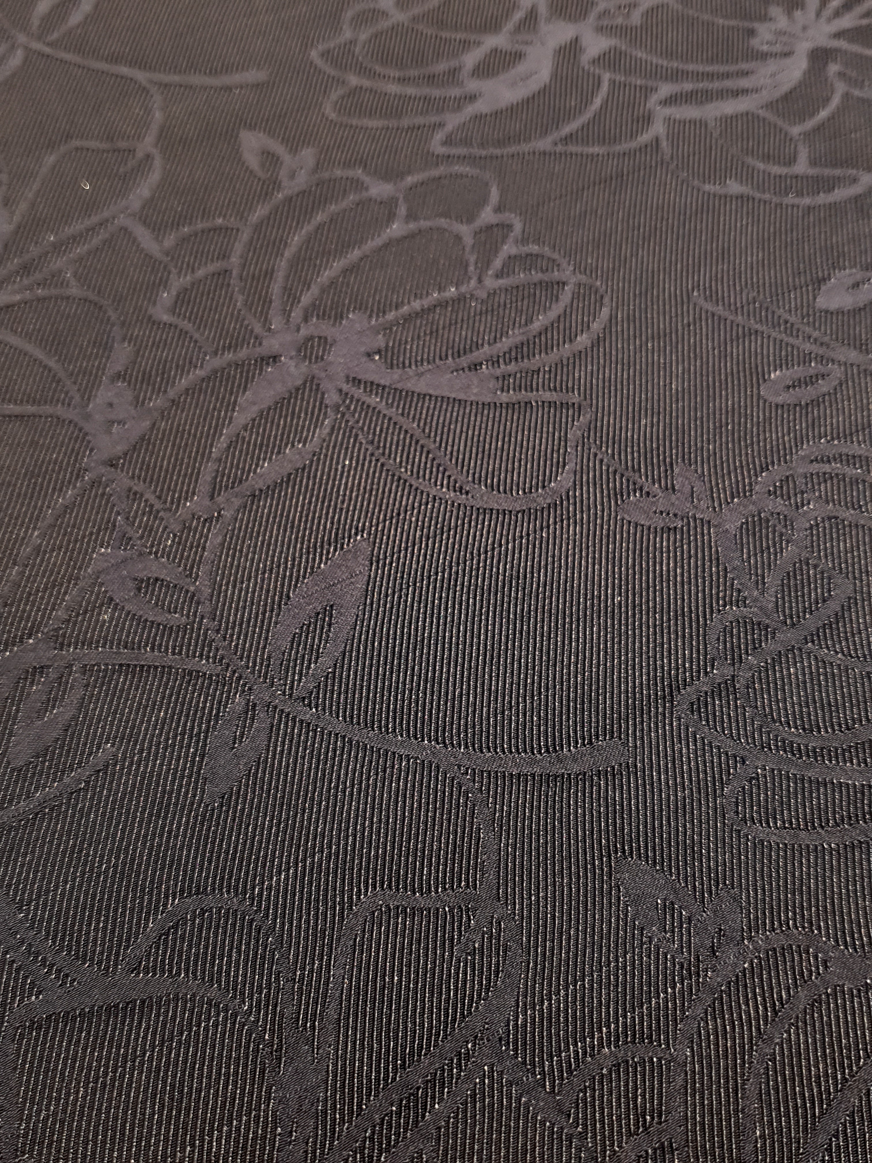 Close detail of structured floral jacquard with woven rayon surface.