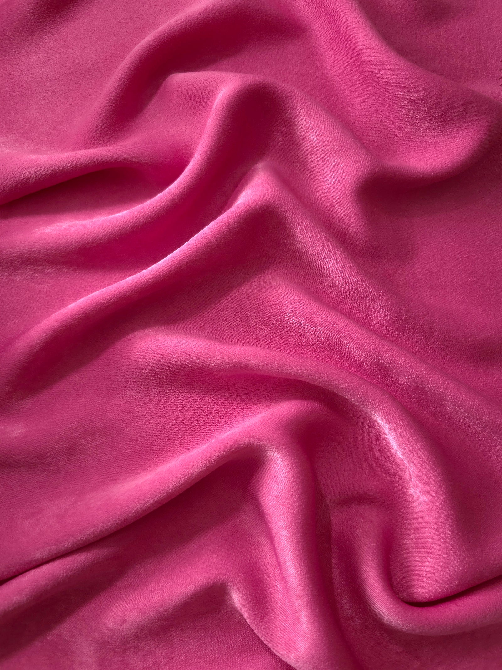 Close-up texture of Raspberry Pink sandwashed silky polyamide fabric