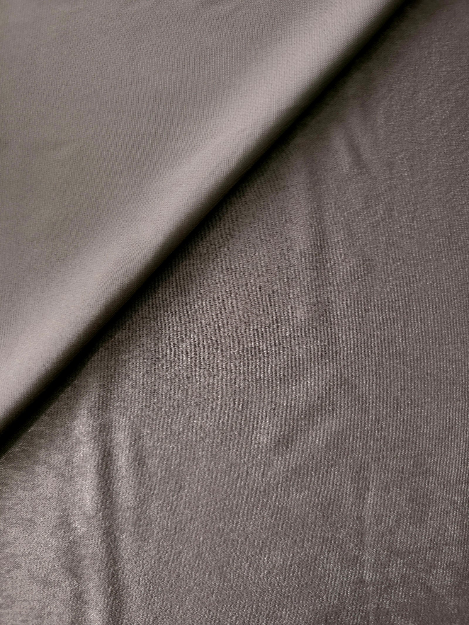 Close-up texture of Smoked Charcoal sandwashed silky polyamide fabric