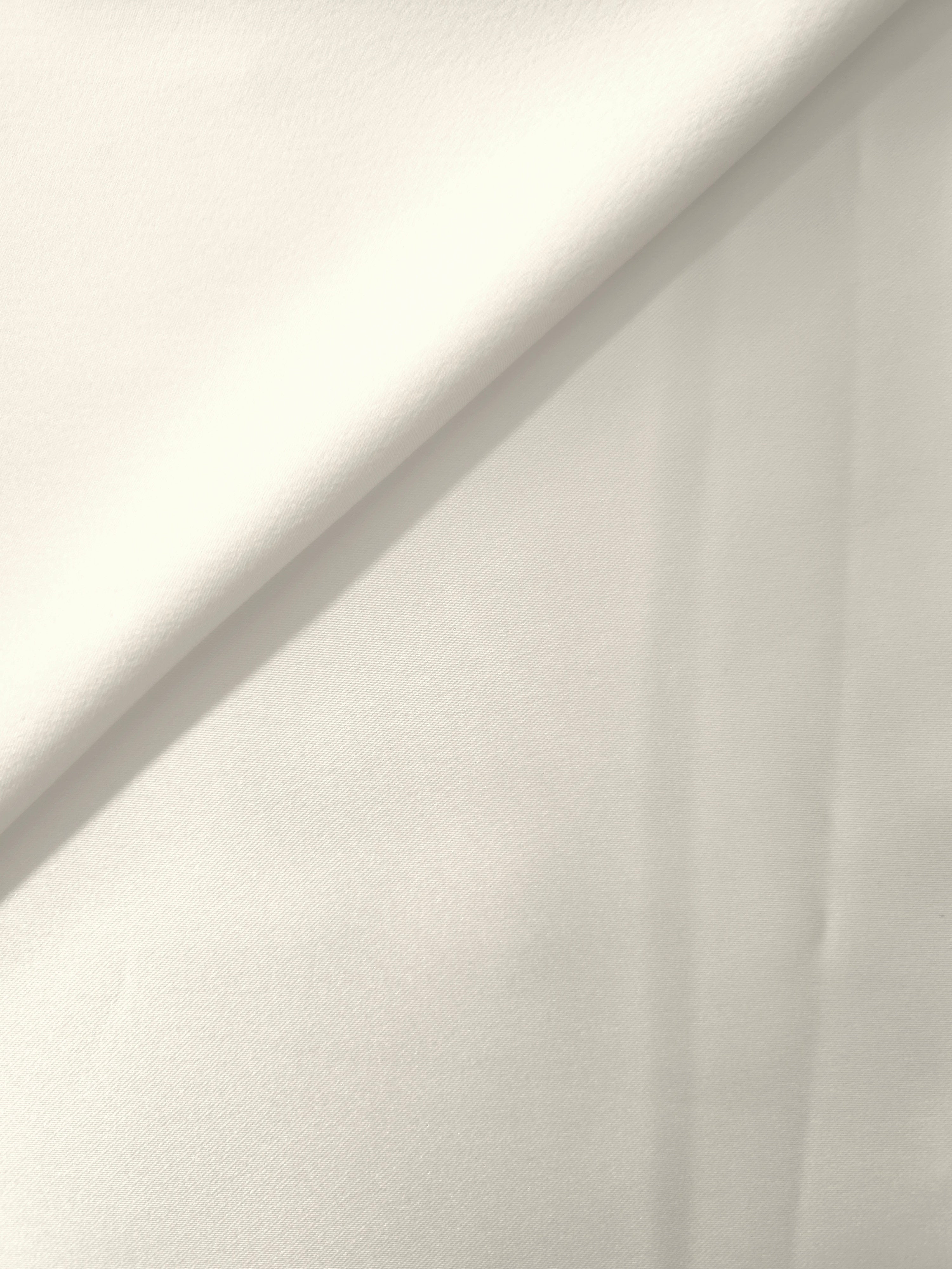 Fold detail of Cloud White satin shows crisp highlights across the silky surface, suited to bridal bodices, formal skirts and decorative sash work.