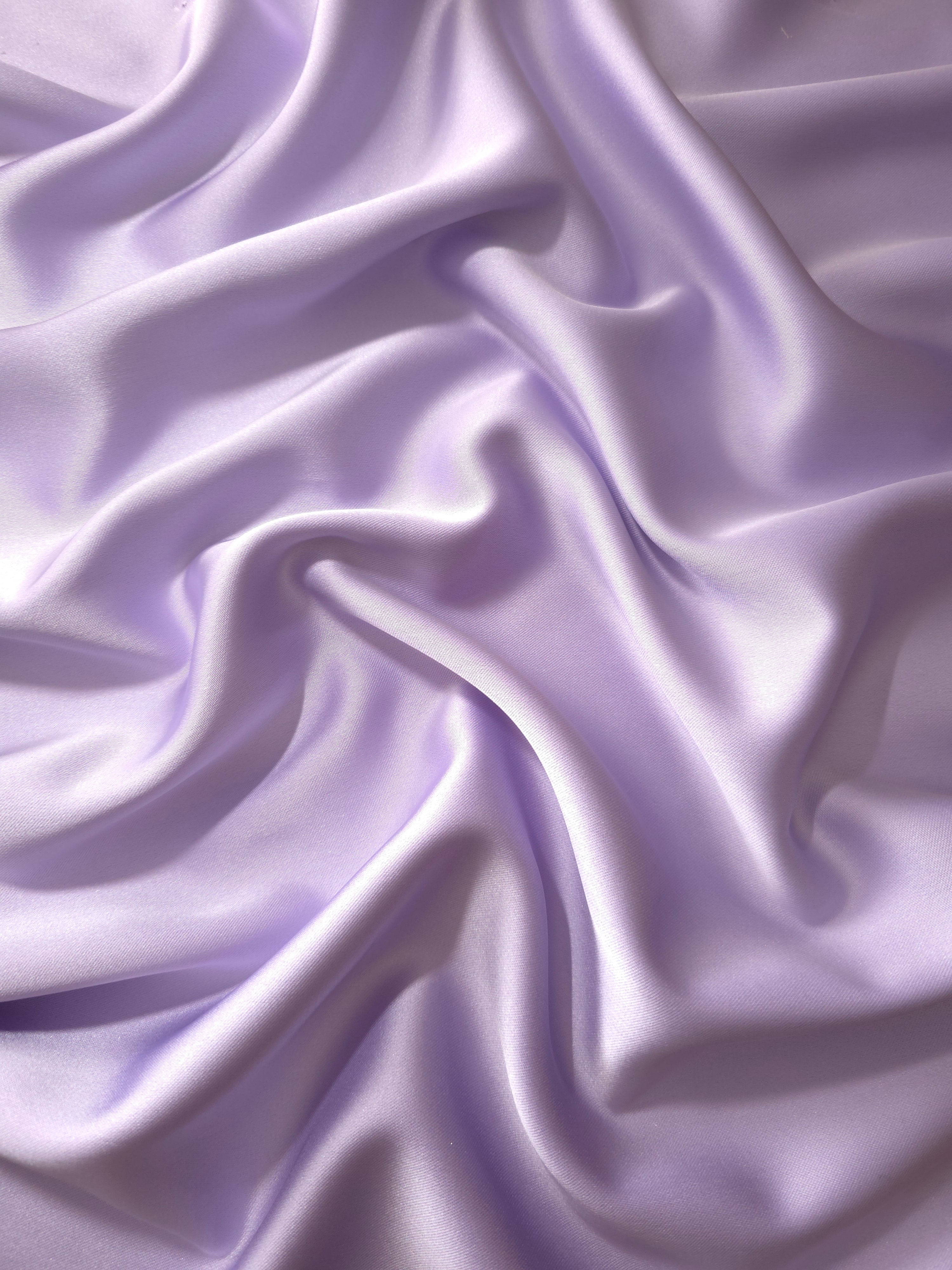 Lilac Lavender silky satin shown draped with soft luminous movement for spring occasion dresses, bridesmaid gowns and flowing maxi skirts.