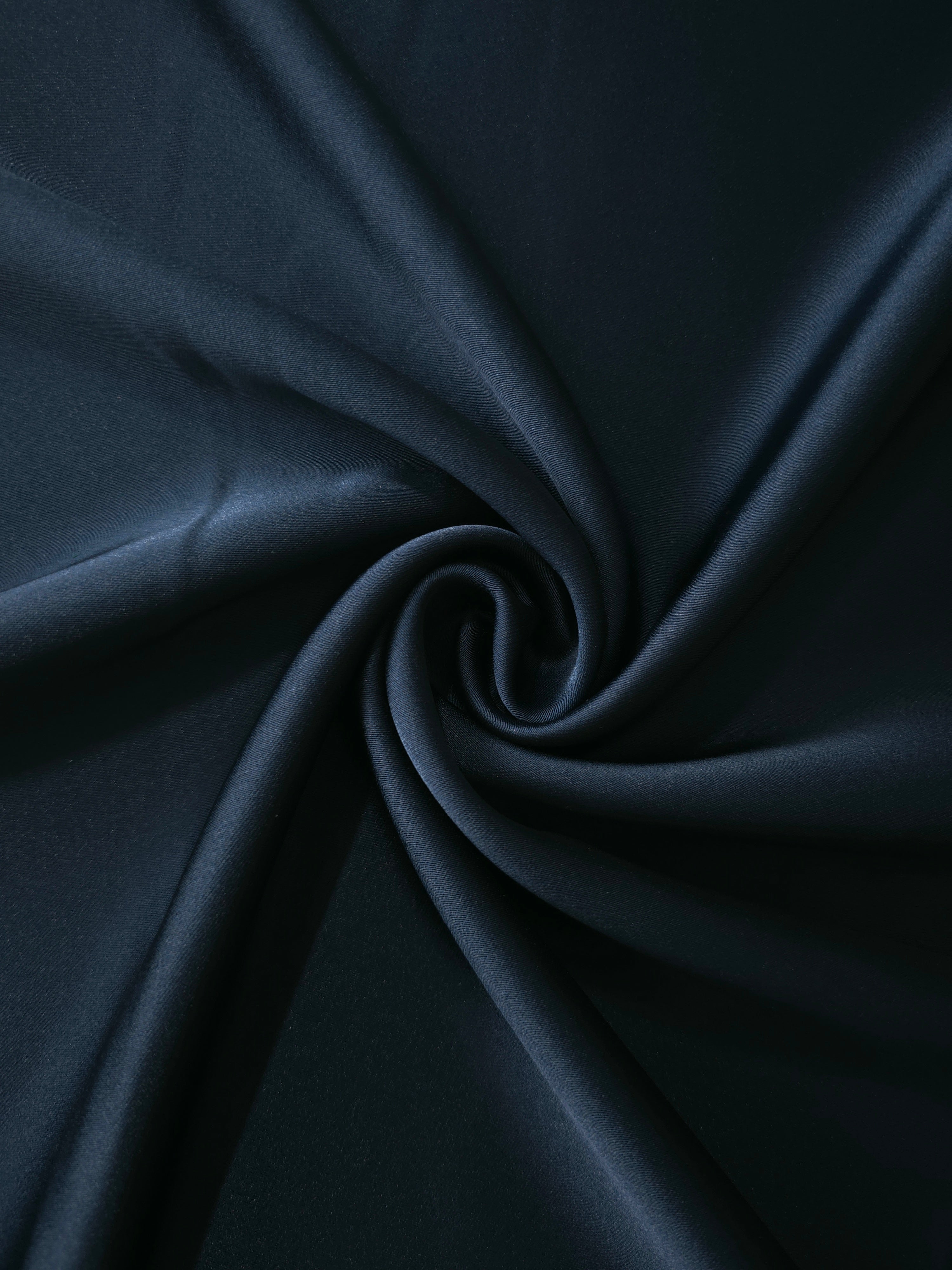 Royal Navy satin shown in a twist drape captures controlled shine and graceful movement for cowl dresses, draped skirts and formal jumpsuit details.
