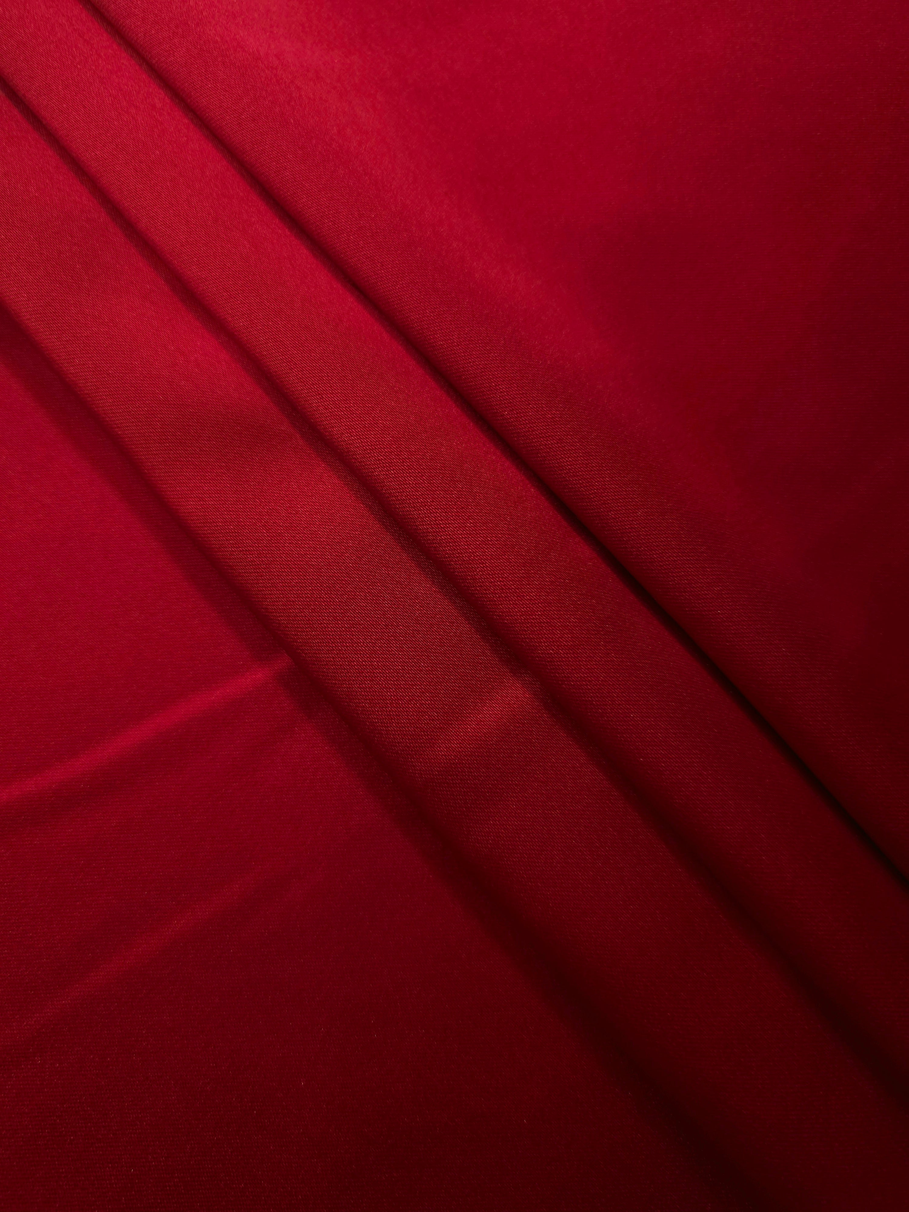 Ruby Red silky satin arranged in relaxed folds reveals fluid movement for slip dresses, luxe robes and romantic occasionwear.