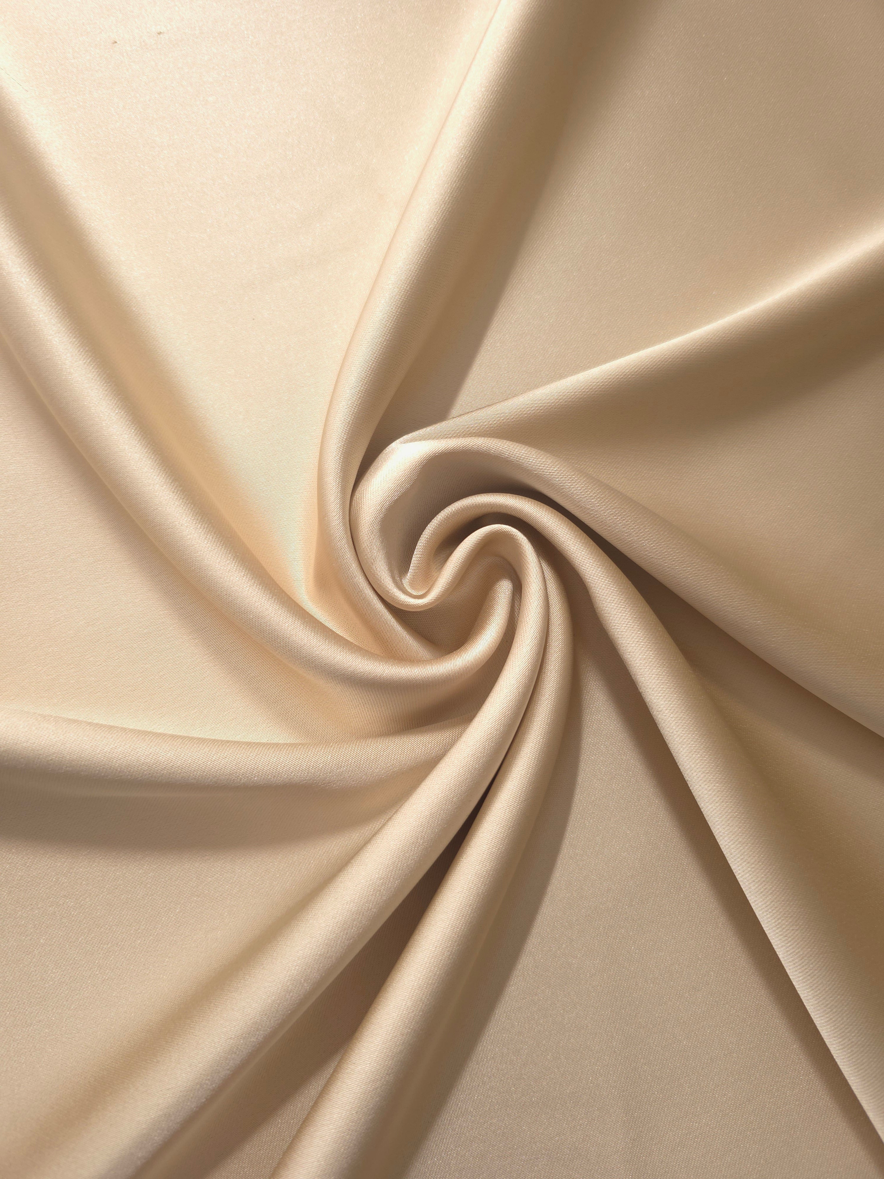 Warm Nude satin twisted into a sculptural drape, revealing graceful flow for cowl-neck dresses, draped skirts and contemporary formalwear.