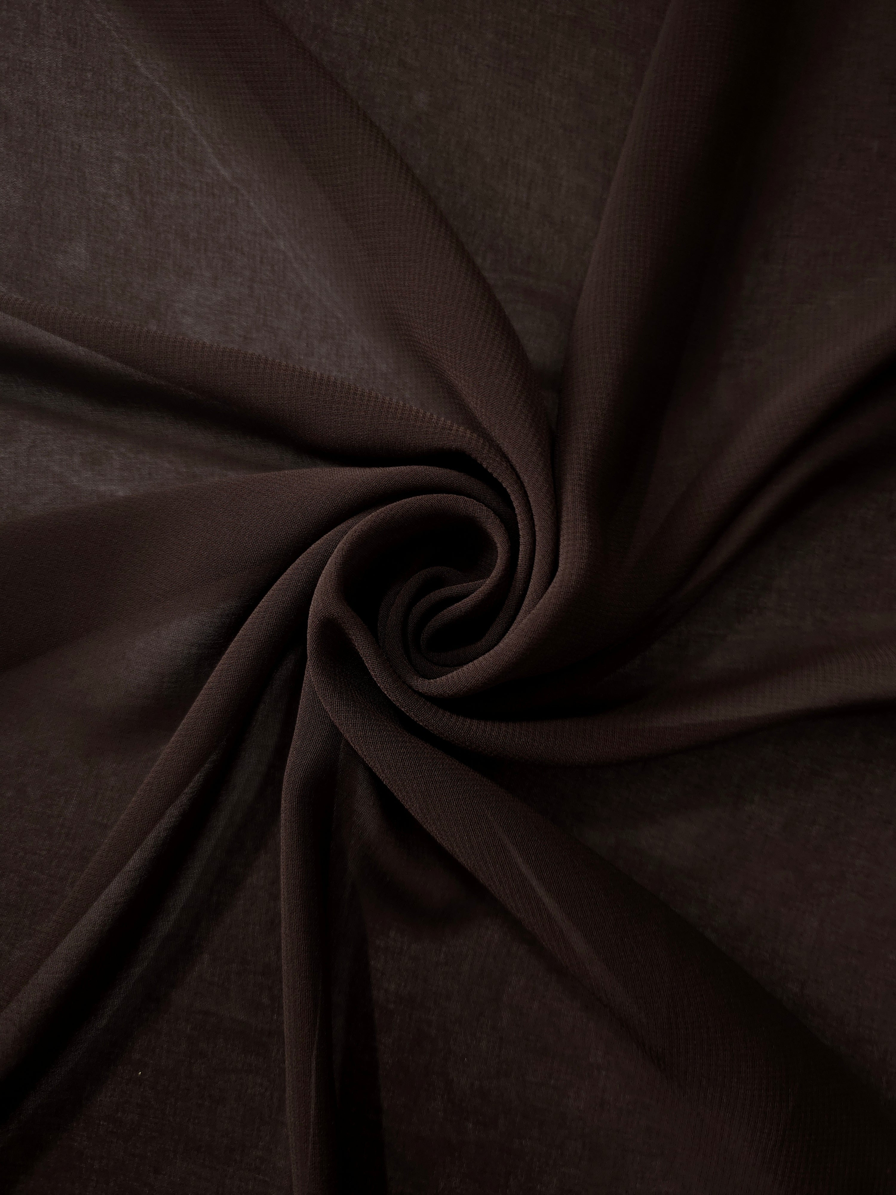 Bitter Chocolate silky chiffon stretch fabric styled in a swirl to demonstrate movement for shawls, gathered extensions and refined occasion details.