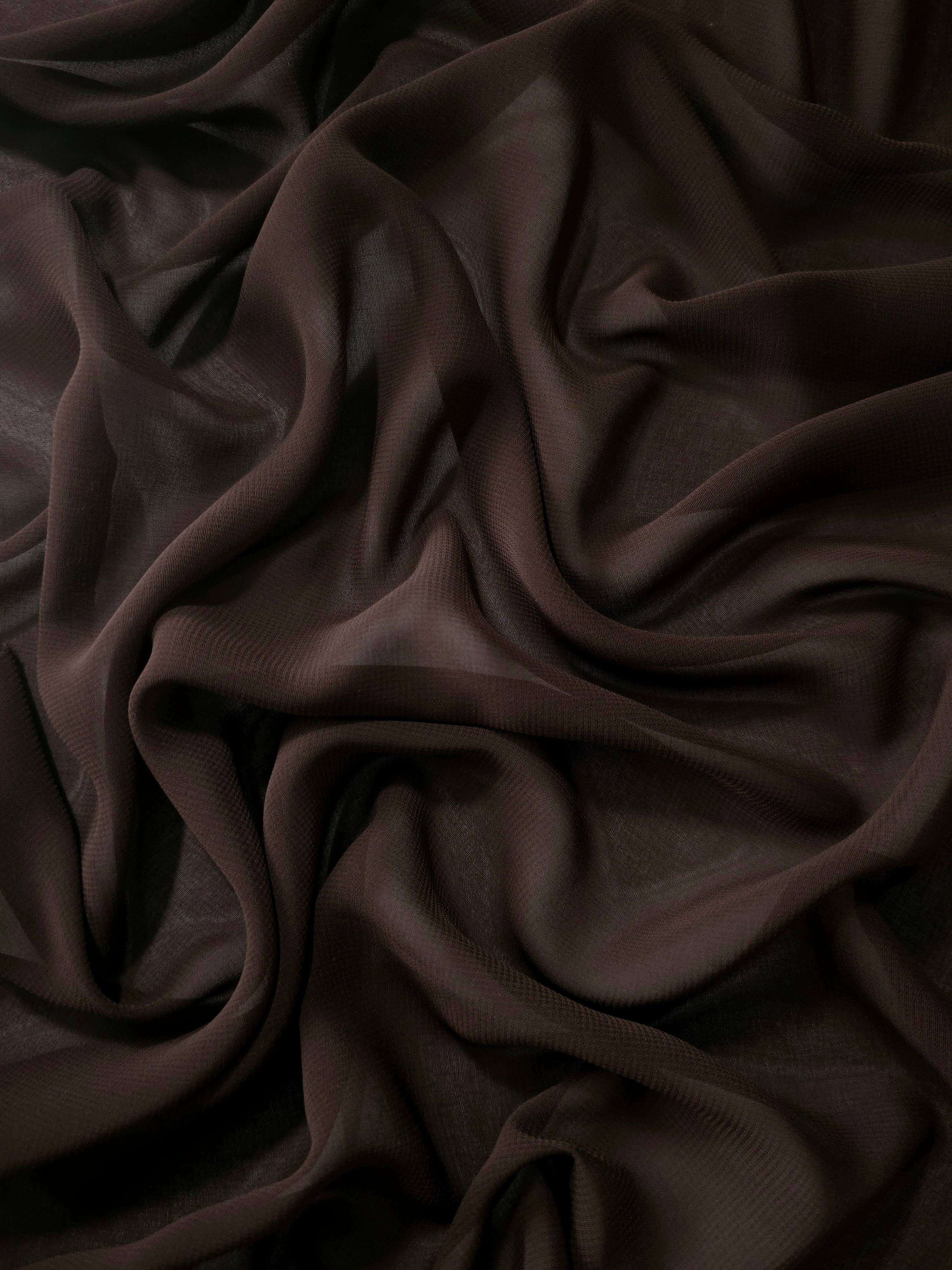 Dark Espresso Brown stretch chiffon arranged in long draped folds to show movement for formal maxi dresses, flowing skirts and elegant layered looks.