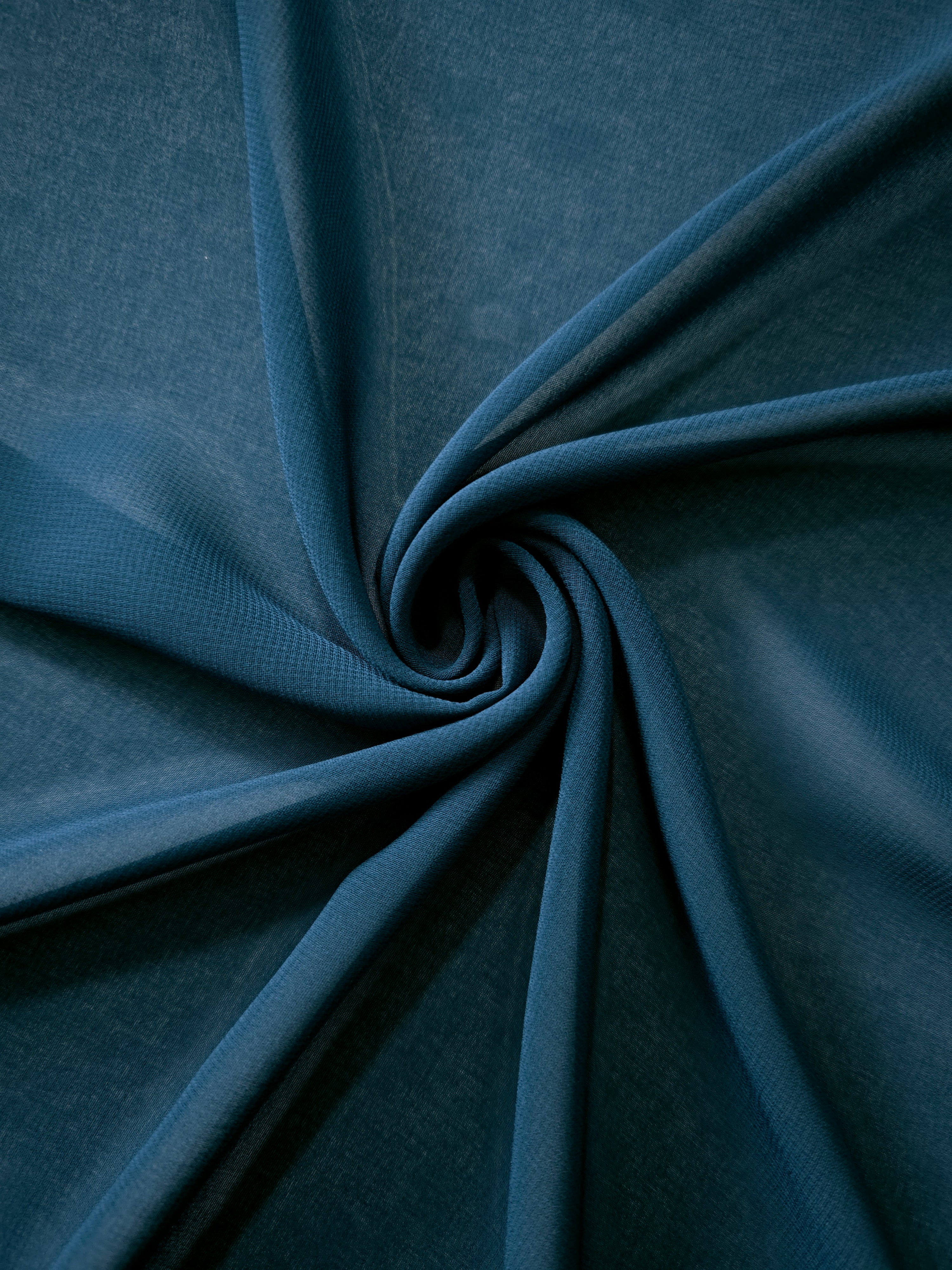 Softly folded Deep Petrol Teal silky chiffon stretch fabric, demonstrating graceful flow for cocktail dresses, draped tops and lightweight shawls.