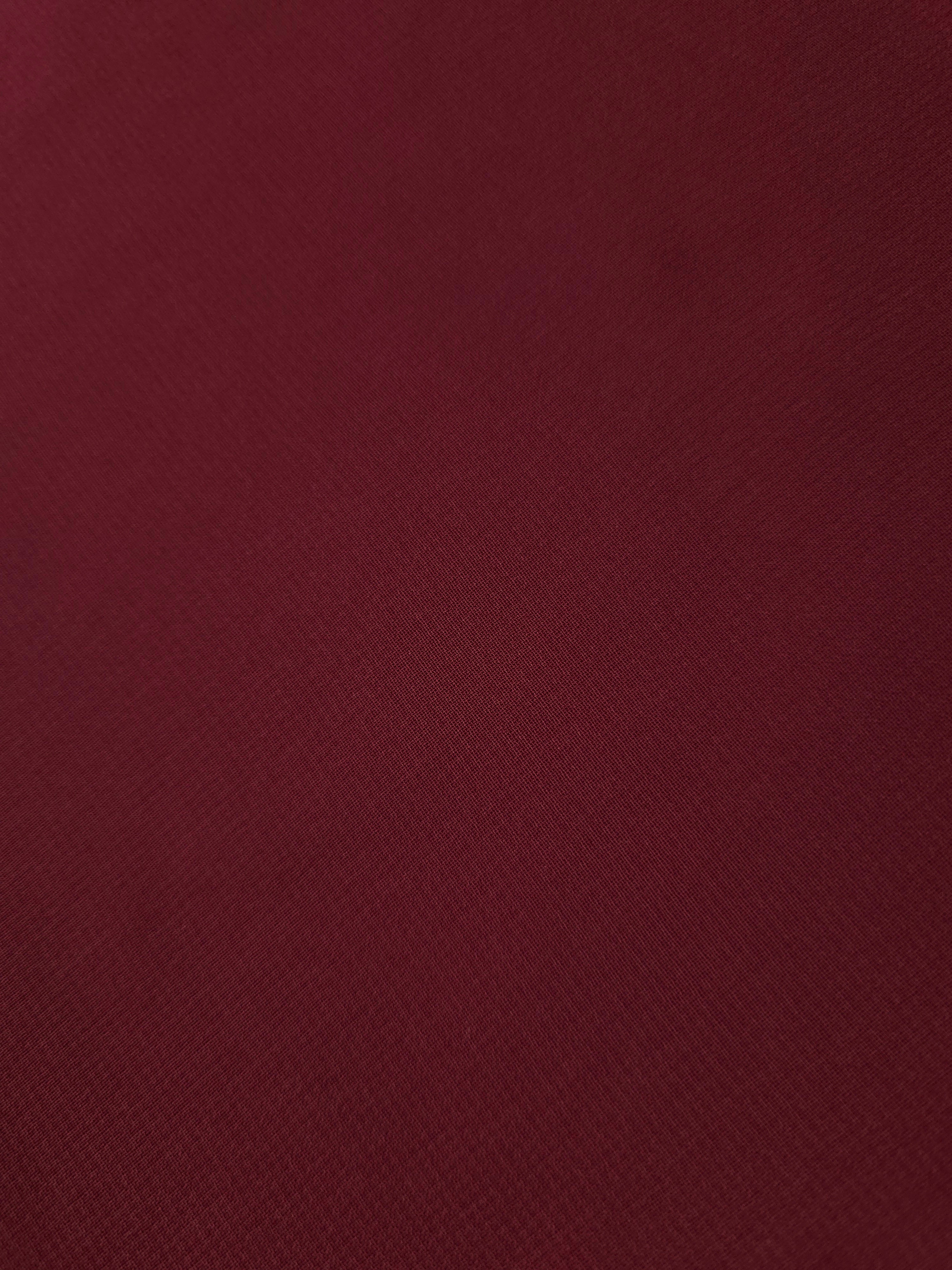 Detailed Garnet Wine chiffon stretch fabric close-up, highlighting its airy texture for sheer sleeves, ruffled accents and elegant bodice inserts.