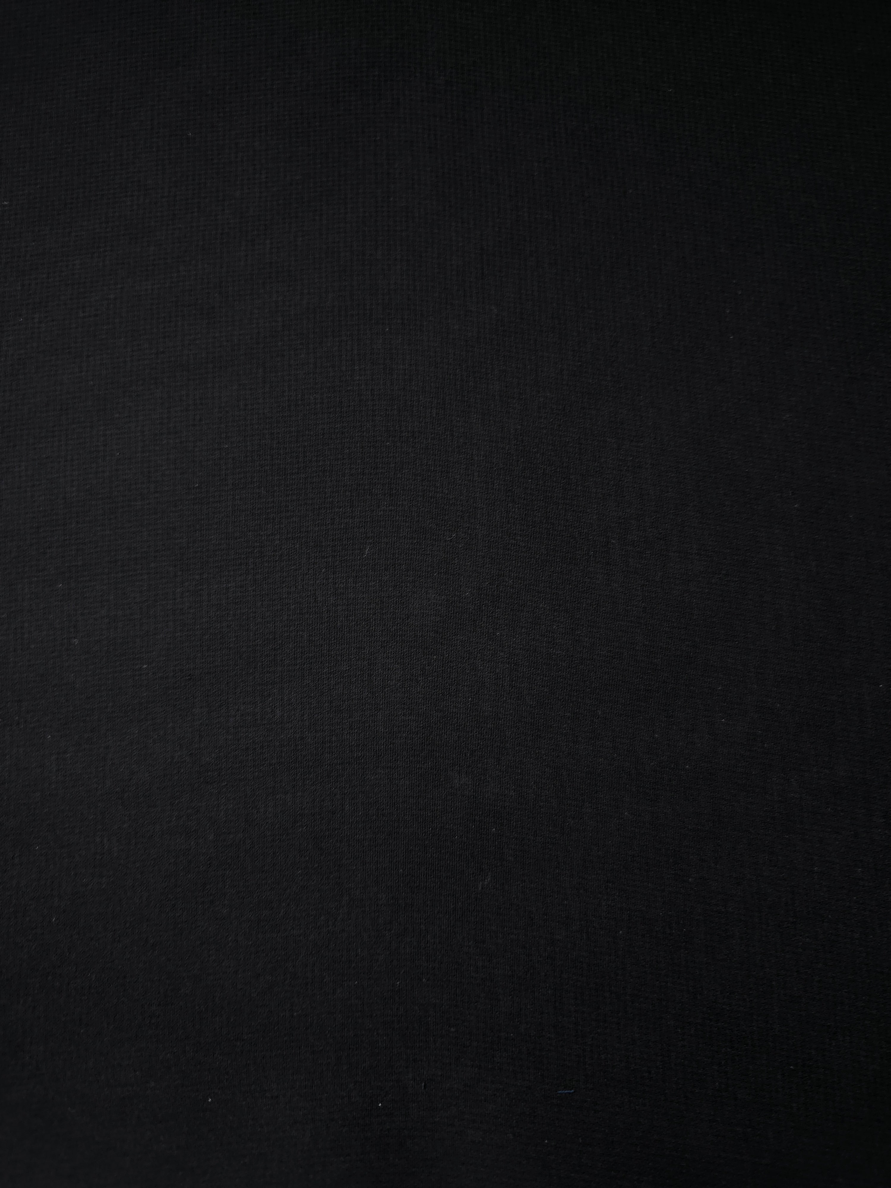 Texture view of Jet Black stretch chiffon, capturing the fine sheer character used for transparent sleeves, ruffles and dramatic neckline inserts.
