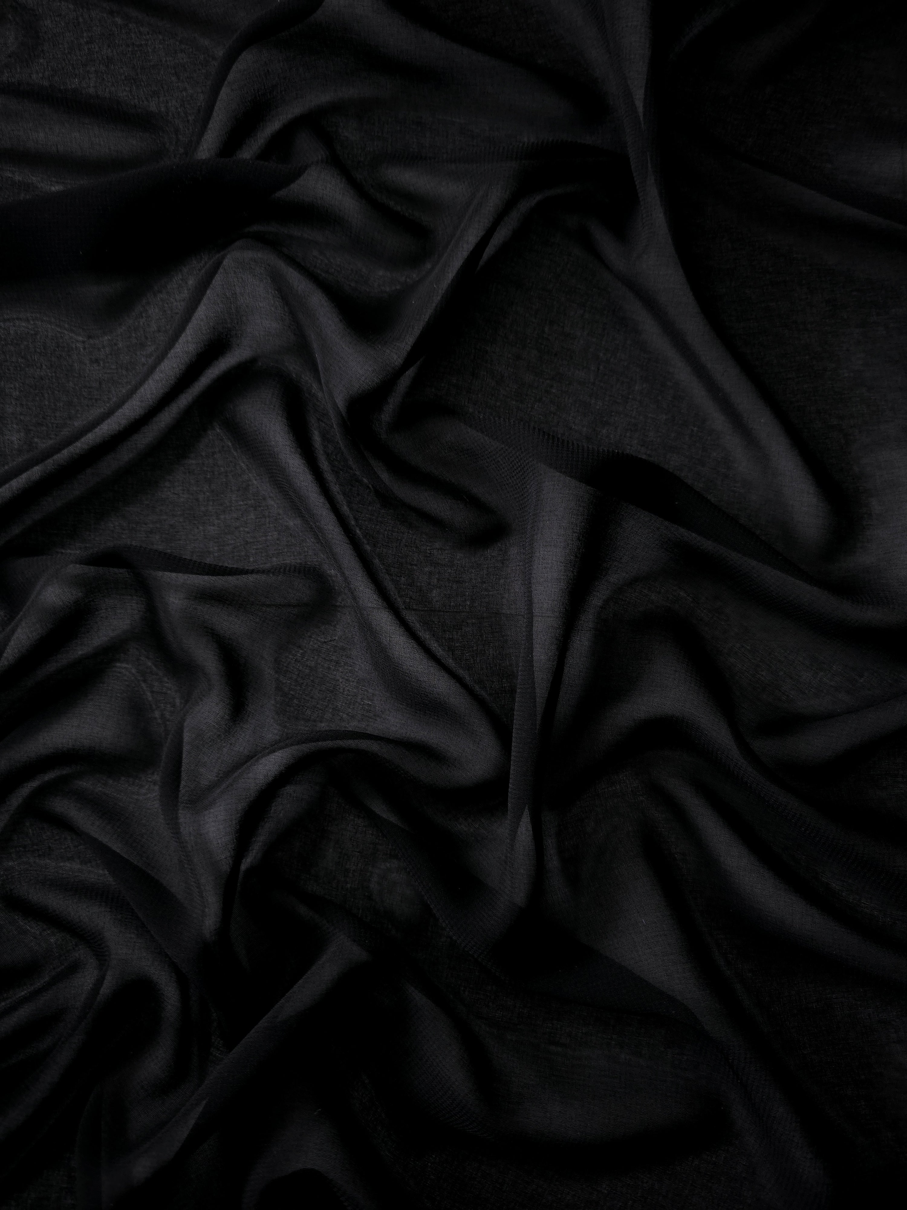 Jet Black silky chiffon stretch fabric styled in a swirl to demonstrate movement for shawls, draped extensions and gathered partywear panels.