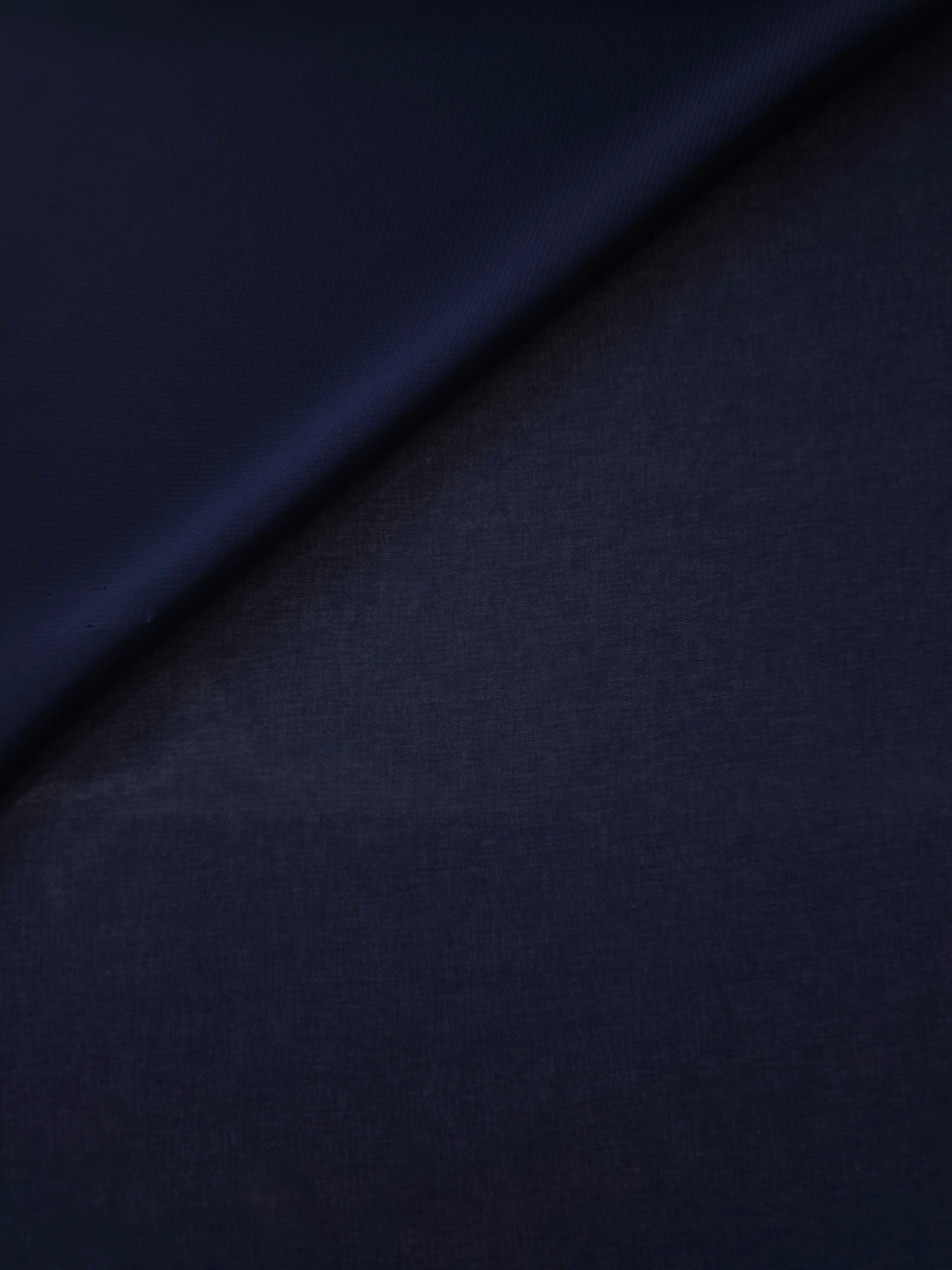 Softly folded Midnight Navy silky chiffon stretch fabric, demonstrating graceful flow for cocktail dresses, draped tops and lightweight shawls.