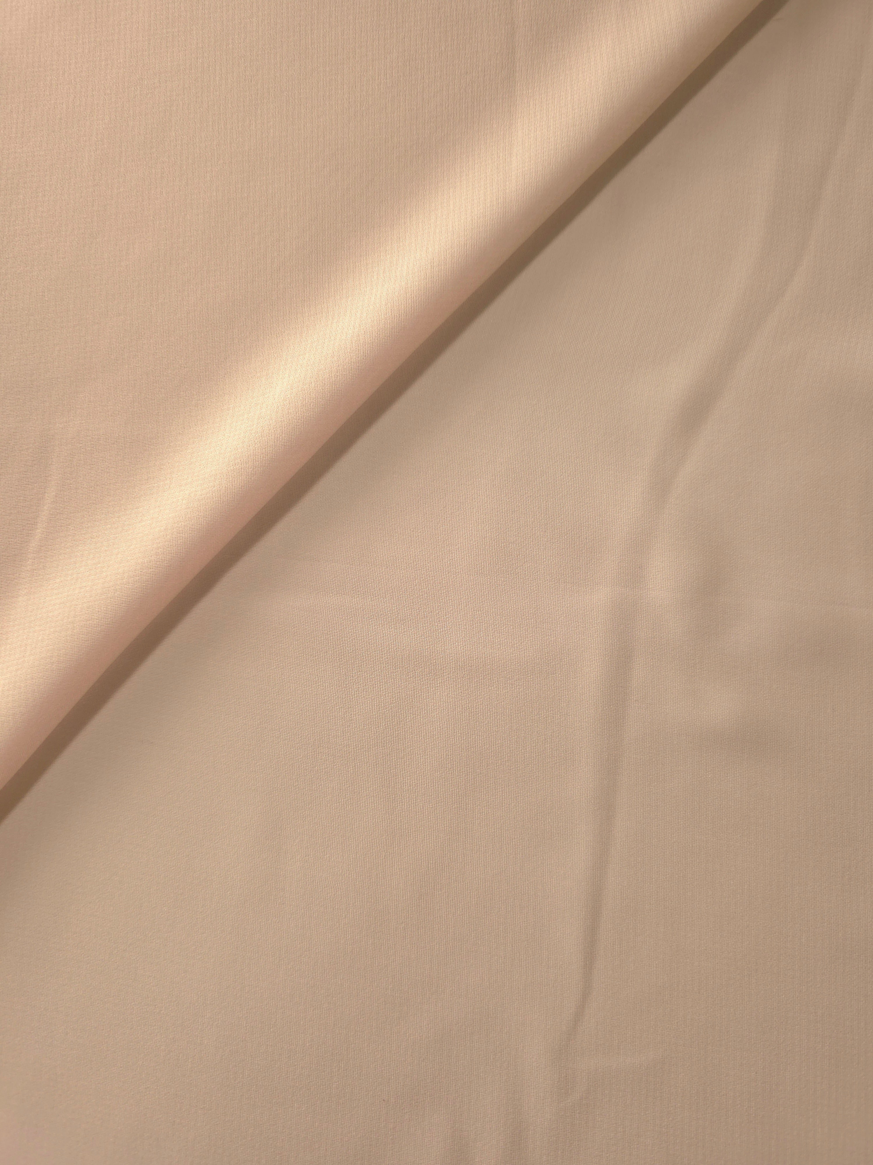Gentle fold of Nude Almond stretch chiffon showing its supple fall and airy body for flowing dresses, draped tops and lightweight scarves.