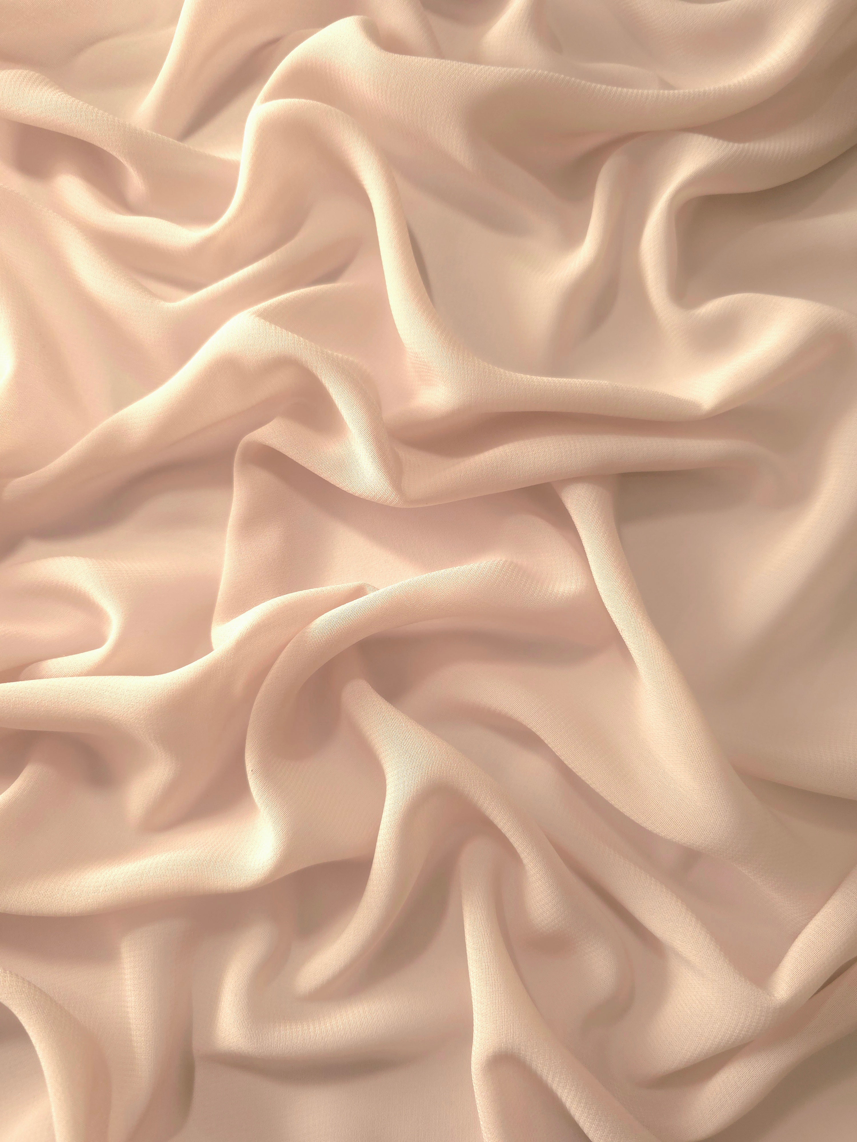 Flowing folds of Nude Almond stretch chiffon highlight its elegant drape for occasion gowns, wrap skirts and softly layered silhouettes.