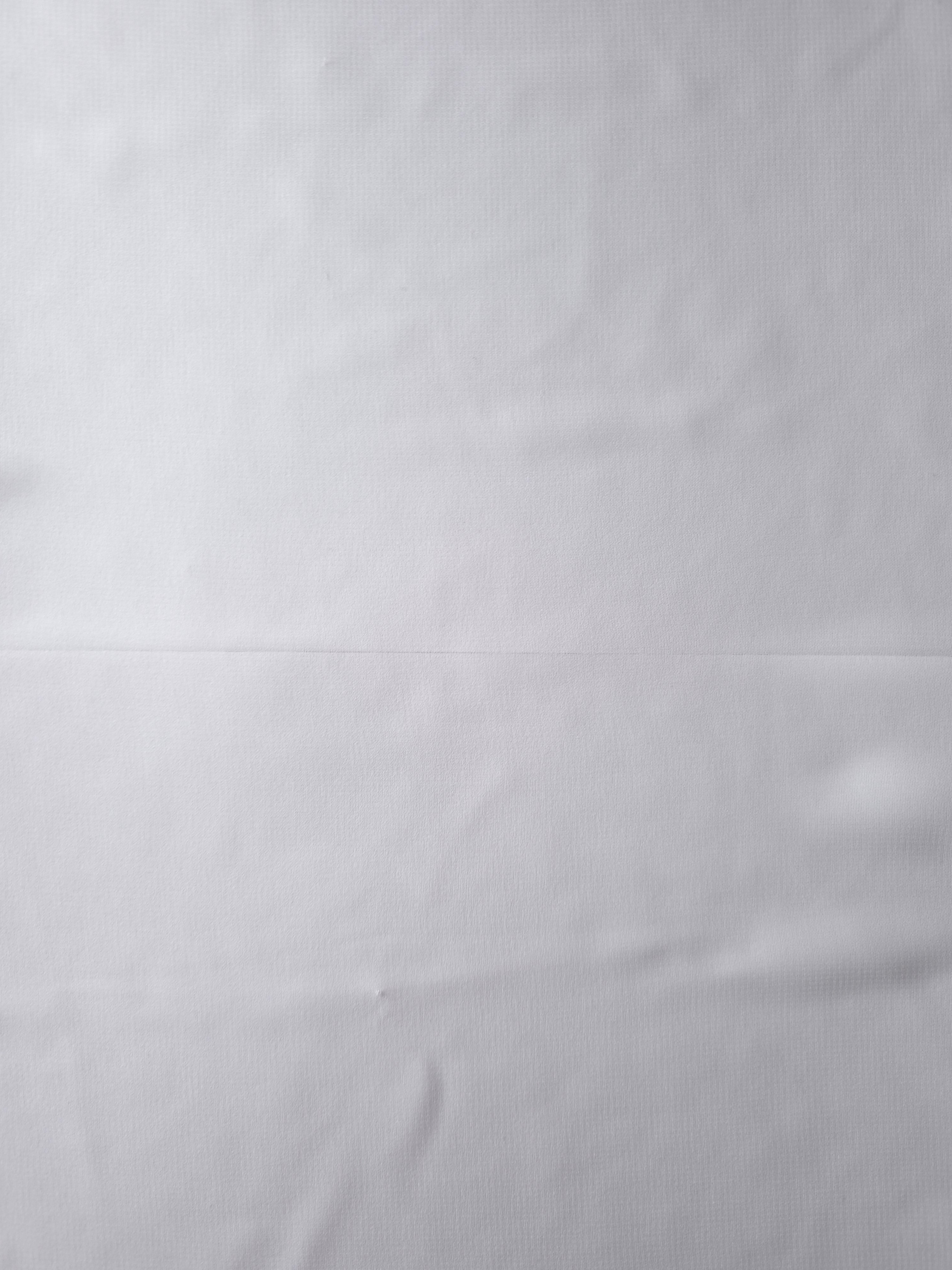 Full surface of Optic White silky chiffon stretch fabric, presenting a light flowing base for bridal veils, wedding overlays and airy blouse panels.