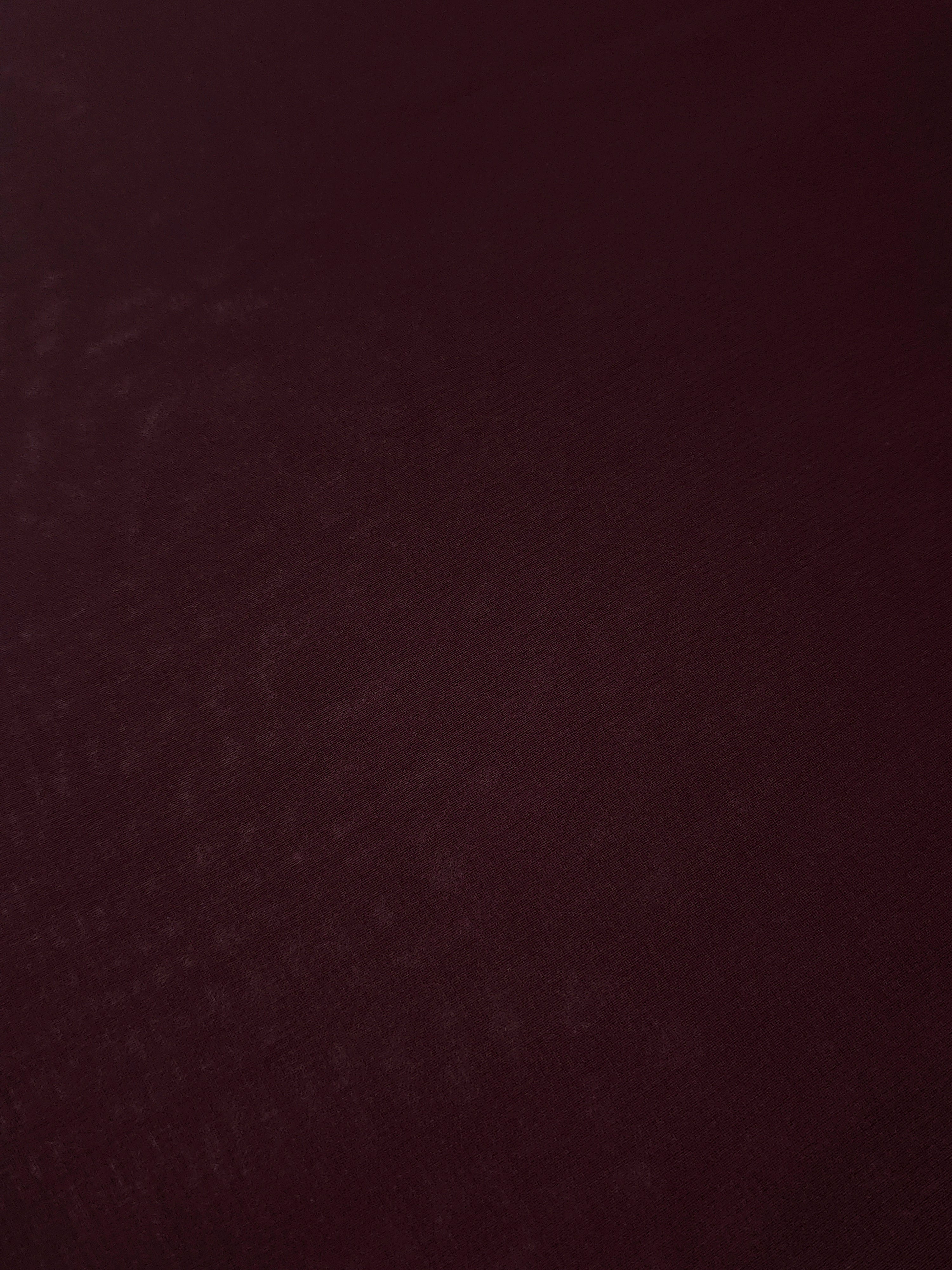 Detailed Oxblood Burgundy chiffon stretch fabric close-up, highlighting its airy texture for sheer sleeves, ruffles and elegant bodice inserts.