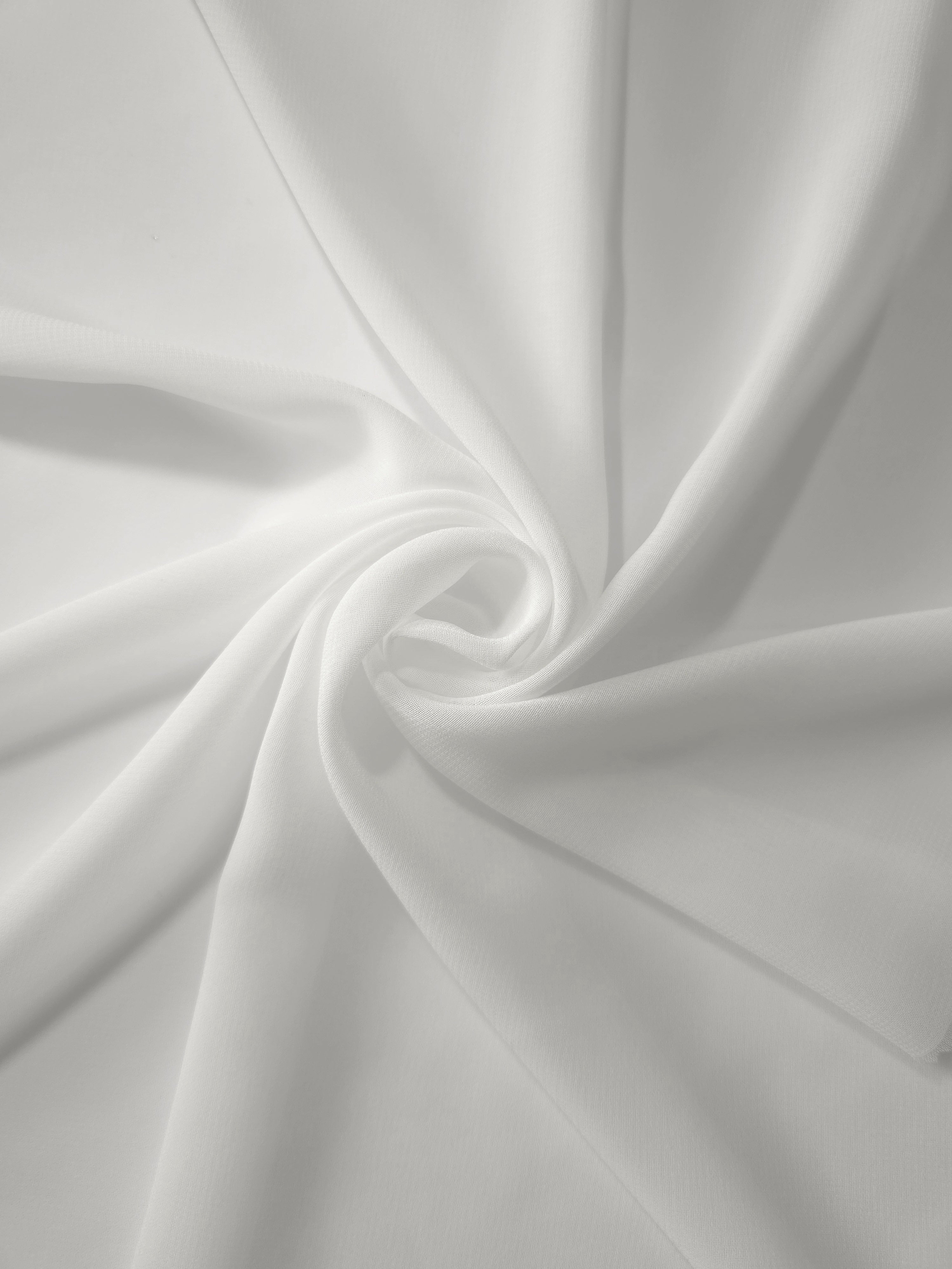 Pearl Ivory stretch chiffon arranged in a swirl, emphasizing airy movement for veils, shawls and softly gathered dress layers.