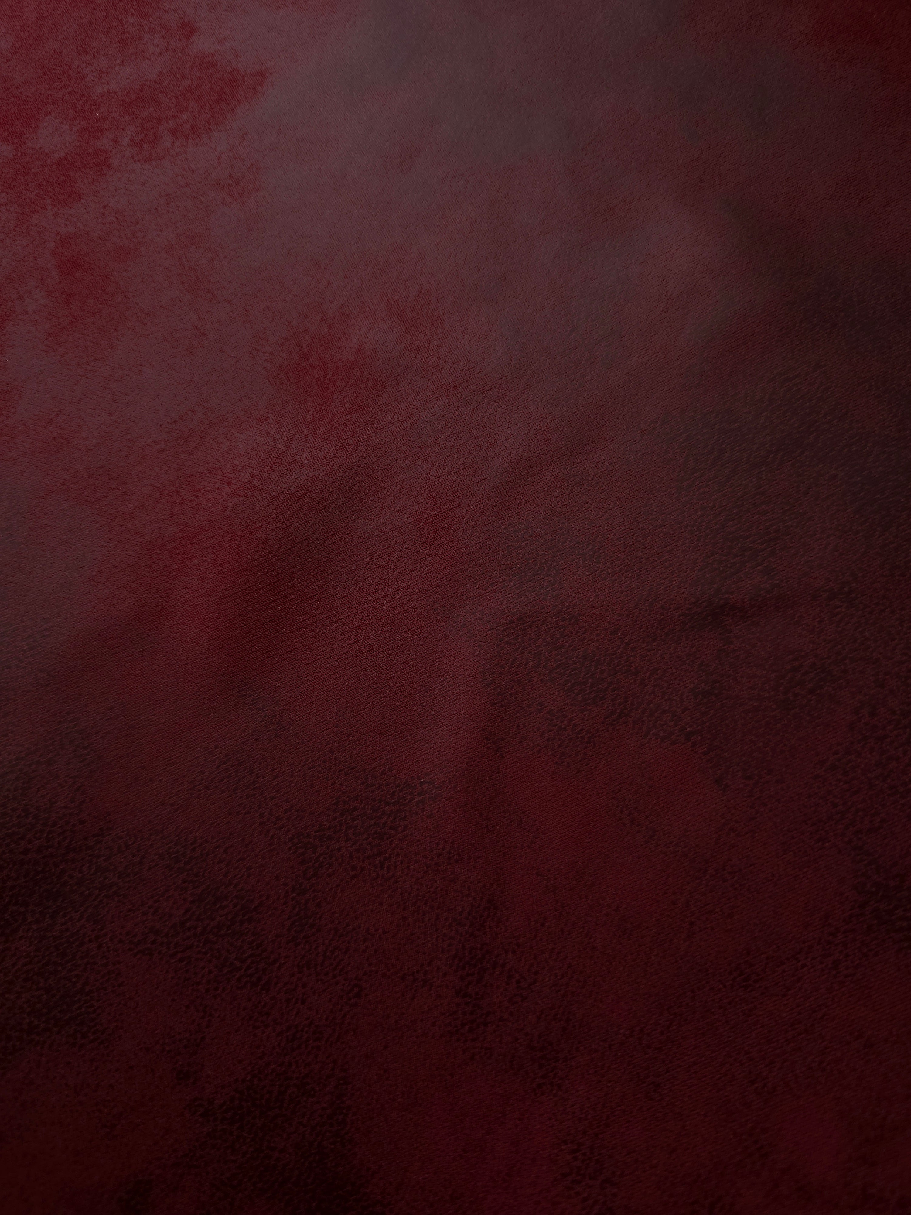 Burgundy red stretch faux leather shown flat to display its smooth finish for bodycon dresses, trousers and statement panels.