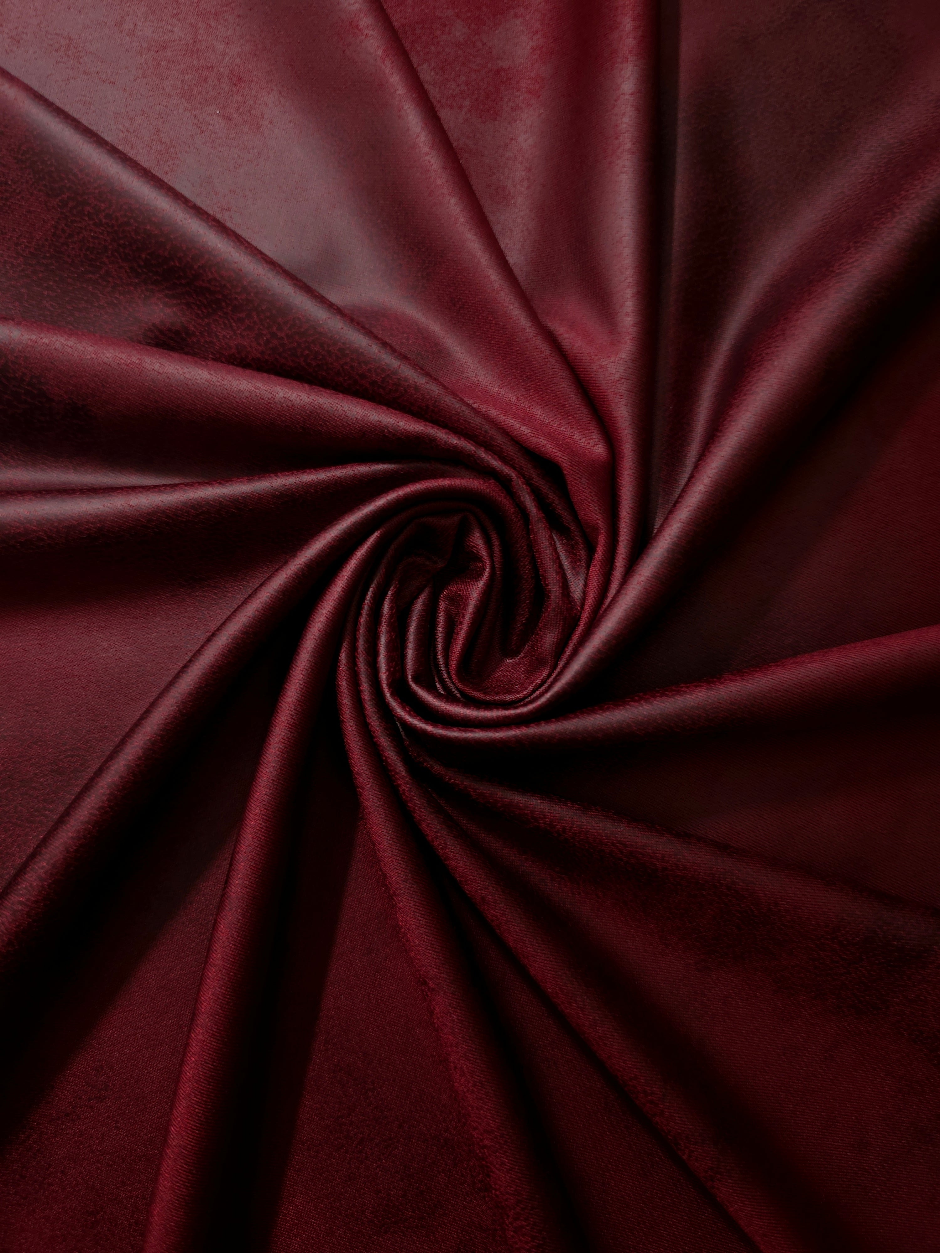 Spiraled burgundy red leather-effect stretch fabric showing supple movement for stagewear, fitted tops and dramatic dress details.