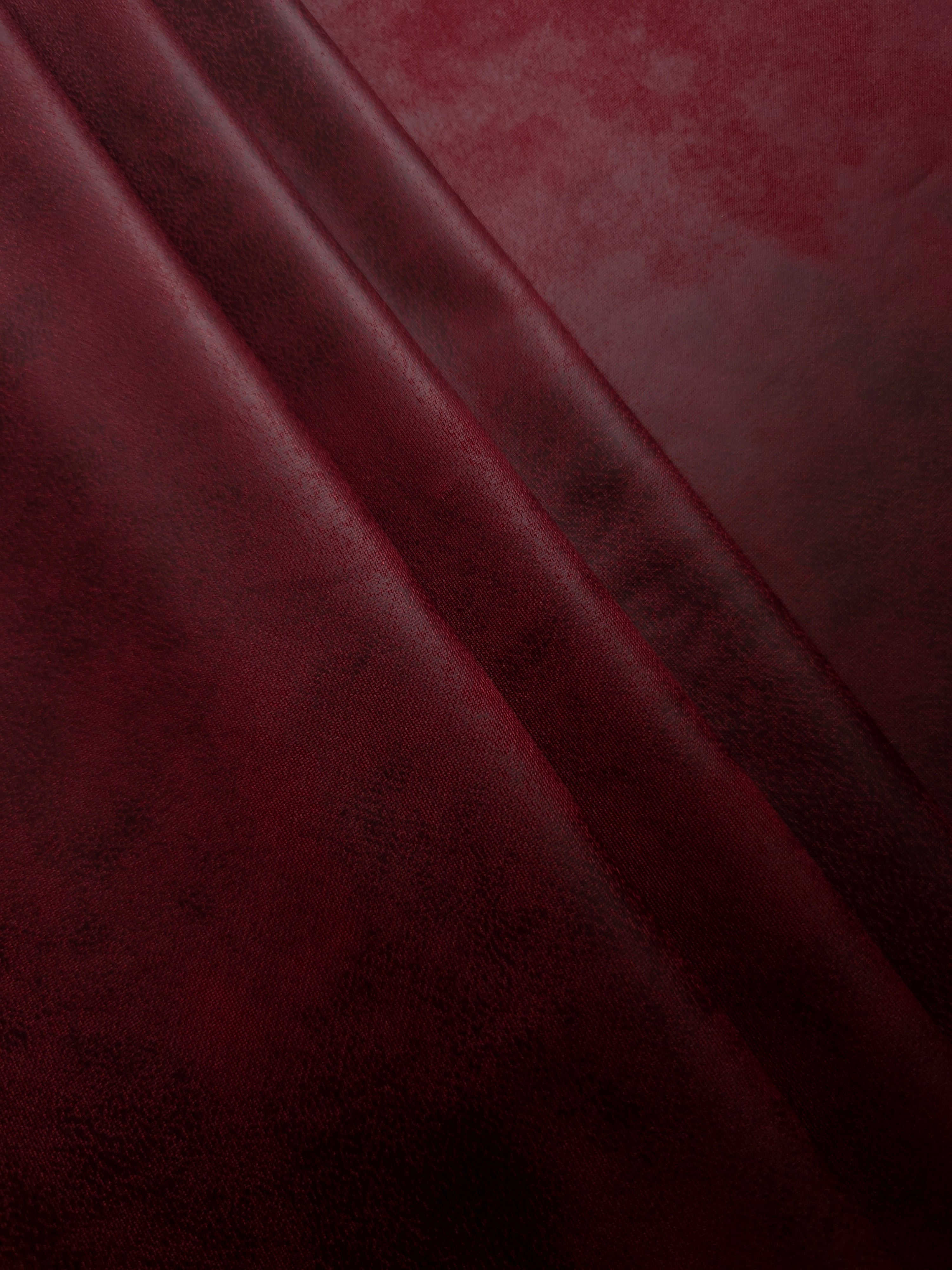 Layered burgundy red stretch faux leather showing soft structure and depth for leggings, skirts and contemporary outerwear accents.