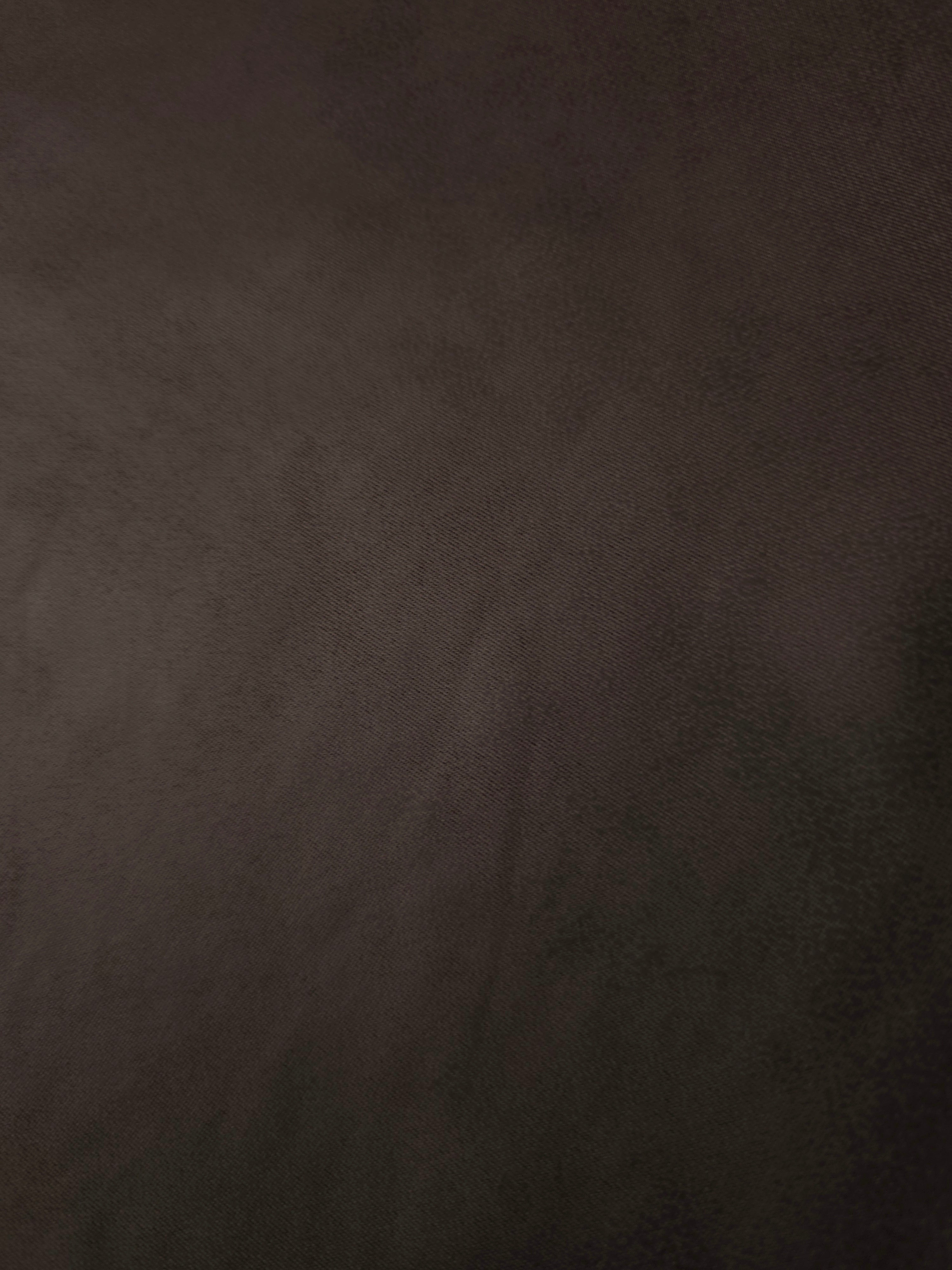Deep espresso brown soft faux leather stretch fabric laid flat, showing a smooth leather-effect surface for fitted skirts and trousers.