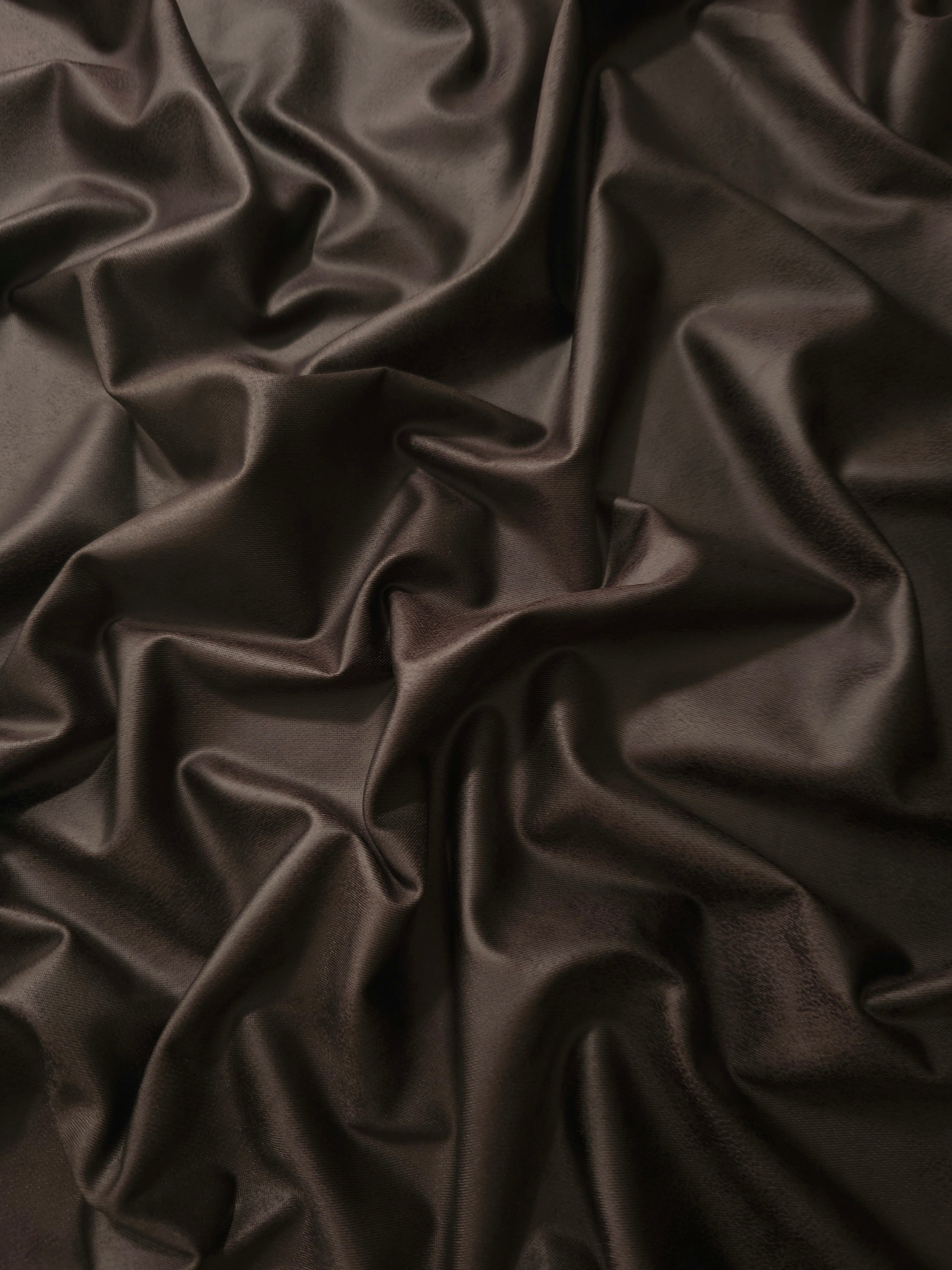 Loose drape of deep espresso brown soft faux leather stretch fabric showing flexible movement for bodycon dresses and pencil skirts.