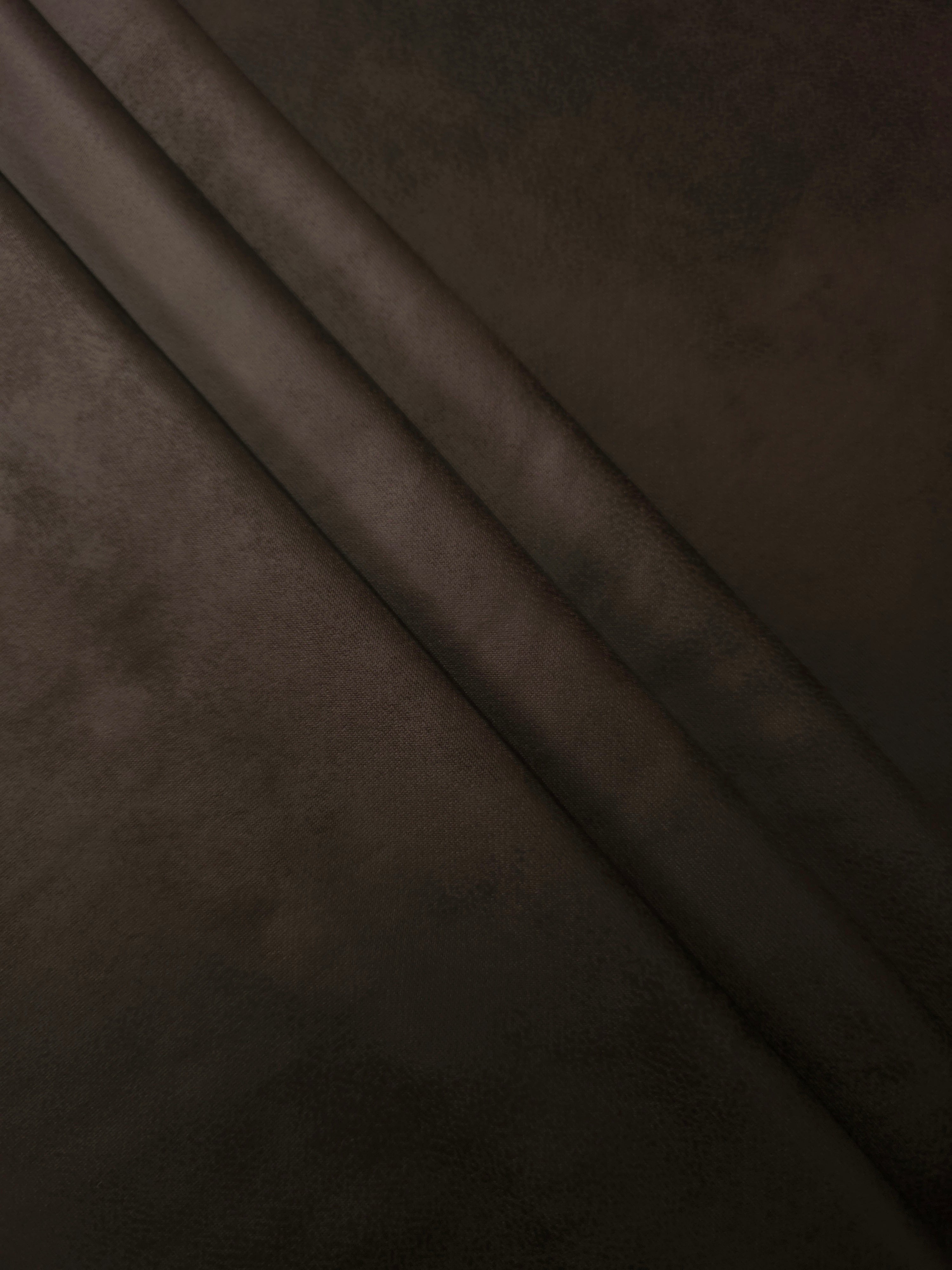 Layered folds of deep espresso brown stretch faux leather showing soft body and recovery for slim trousers, skirts and fitted separates.
