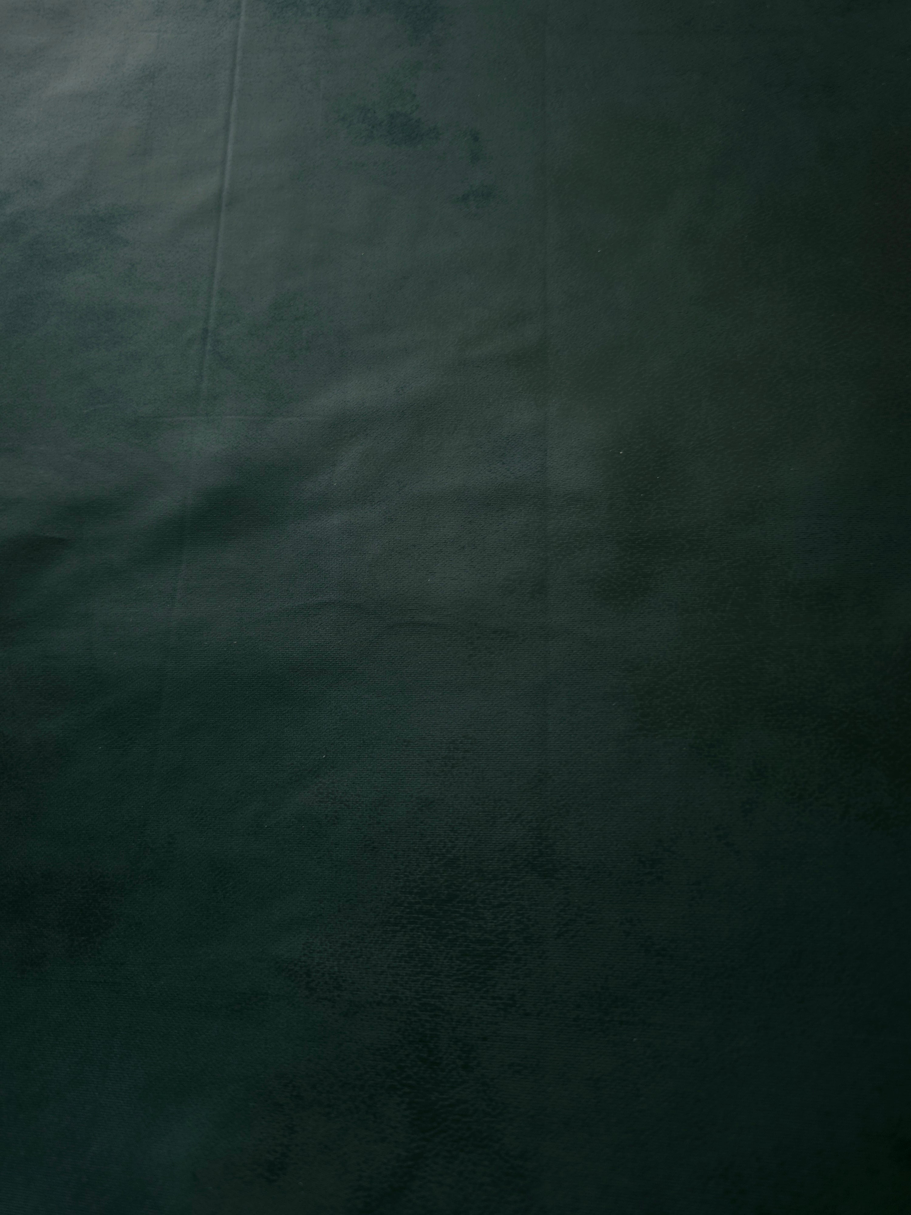 Close-up of deep forest green soft faux leather stretch fabric showing refined leather-effect texture for corset tops and fitted skirts.