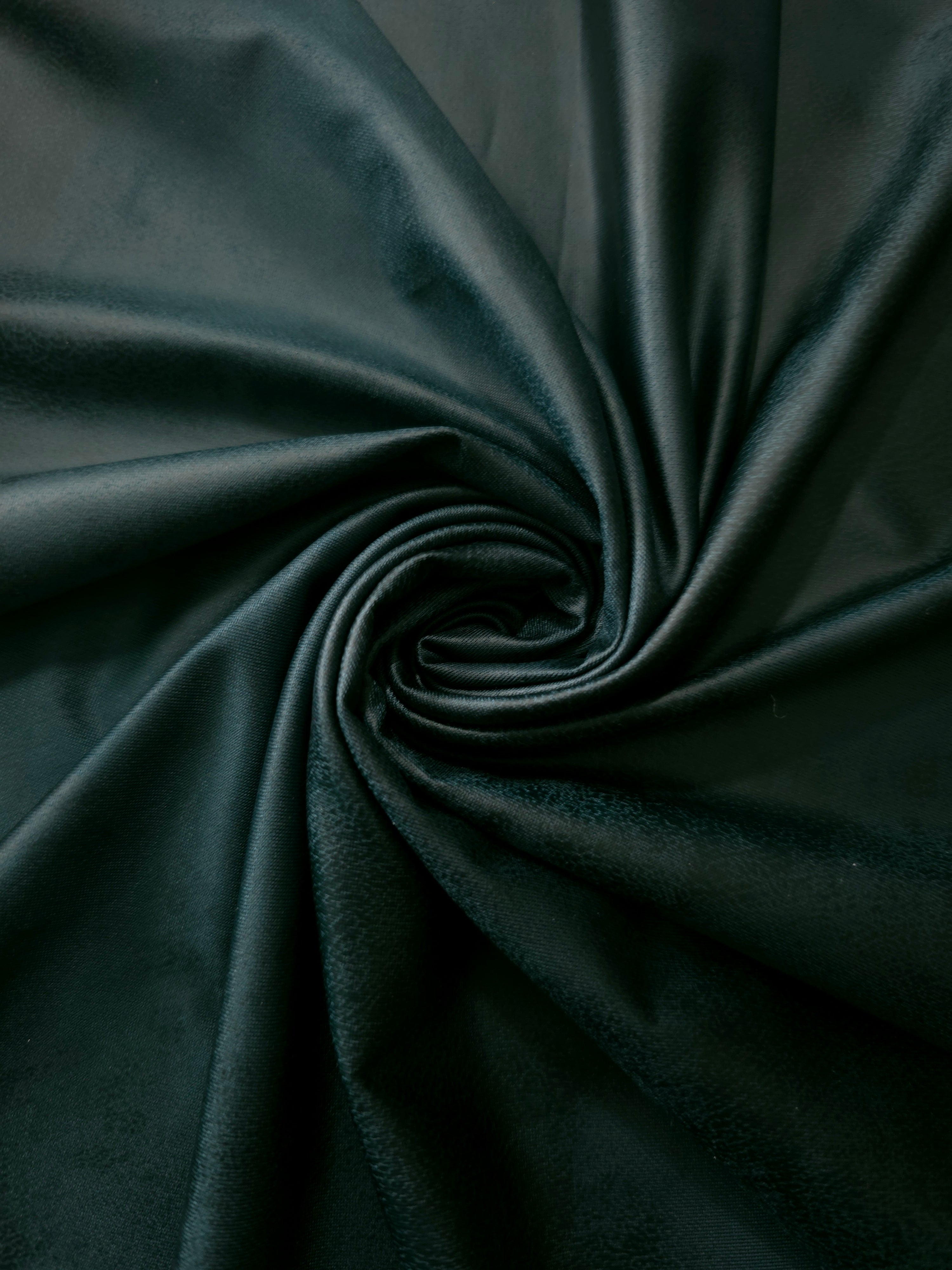 Spiral drape of deep forest green leather-effect stretch fabric showing fluid shaping for statement tops, costumes and occasionwear.