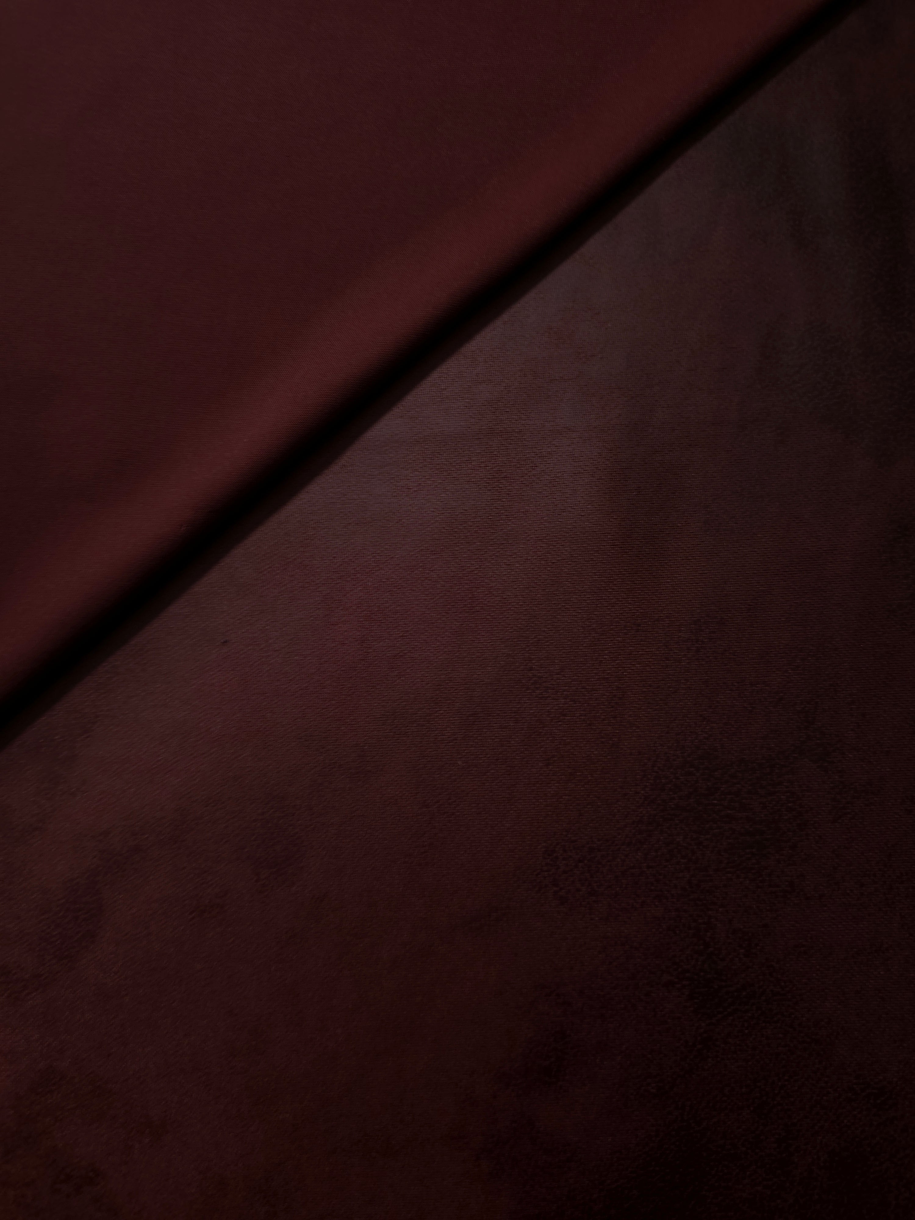 Front and backing view of deep plum faux leather stretch fabric for assessing finish in jackets, structured tops and costume pieces.