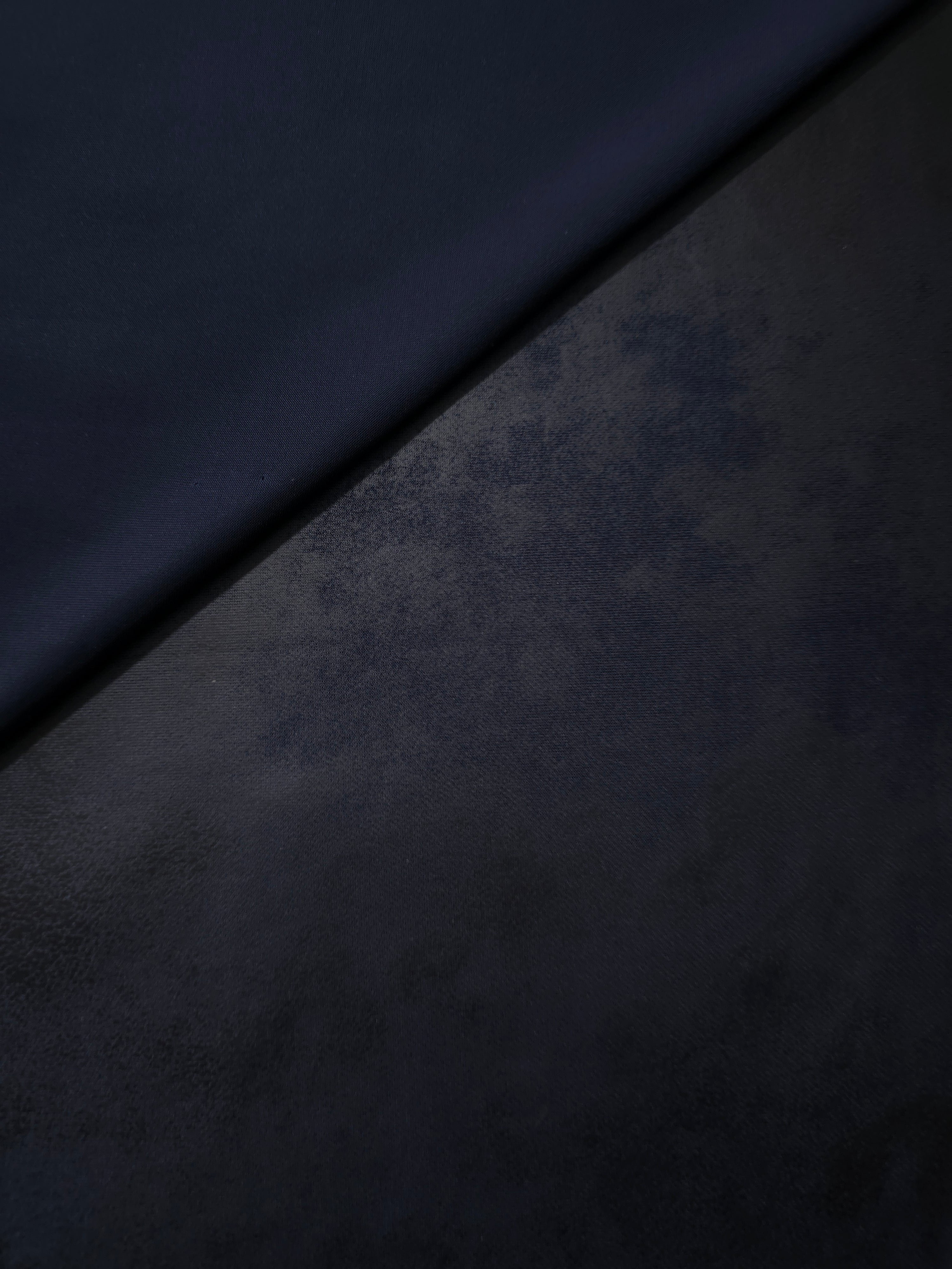 Front and reverse view of midnight navy faux leather stretch fabric for evaluating finish in jackets, bustiers and structured pieces.