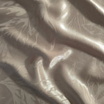 Branch tonal viscose jacquard fabric in a wave fold, showing silky sheen