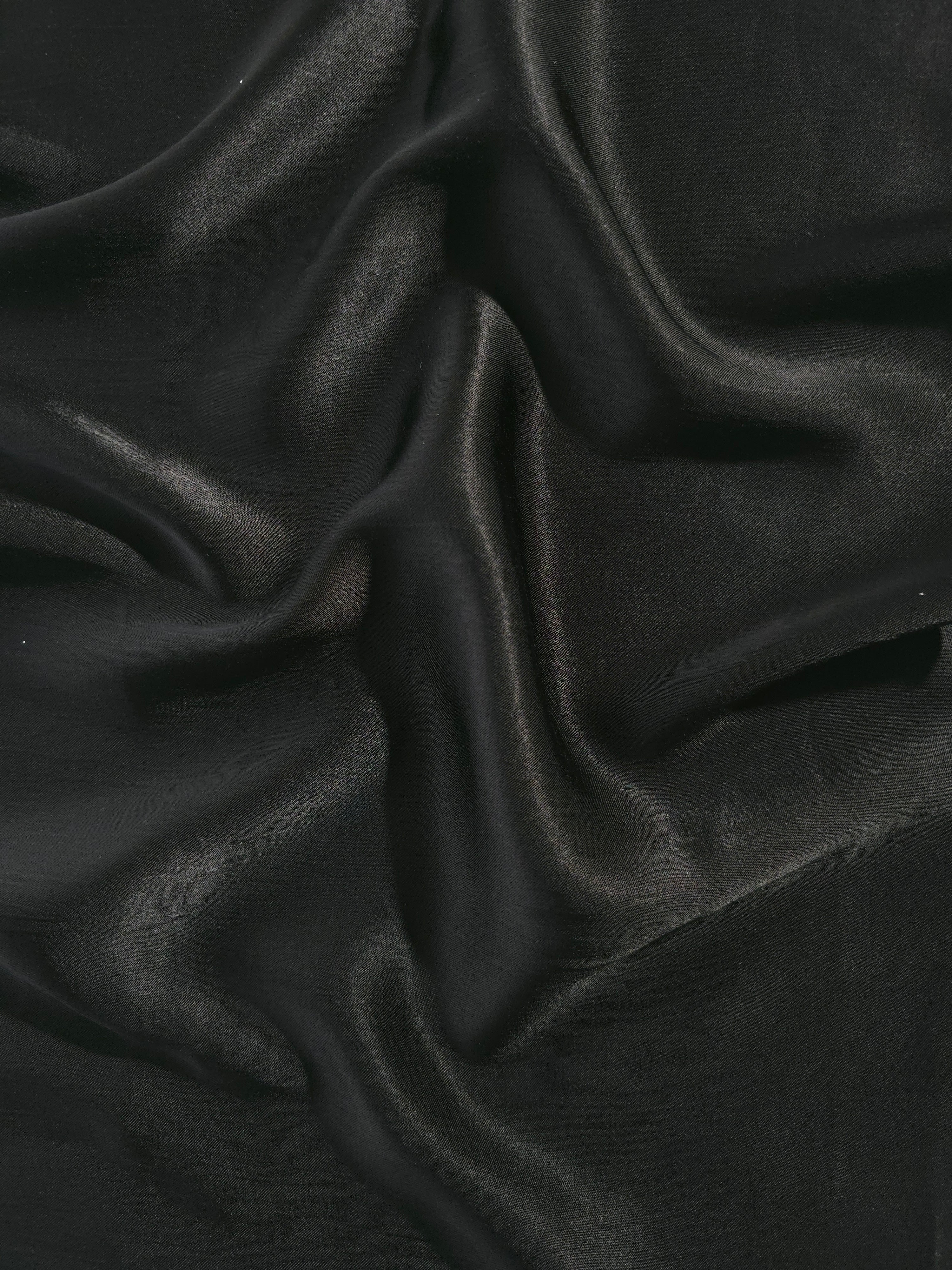 Flat tonal viscose jacquard fabric in a wave fold, showing silky sheen