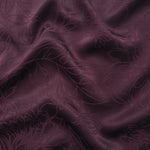 Floral tonal viscose jacquard fabric in a wave fold, showing silky sheen