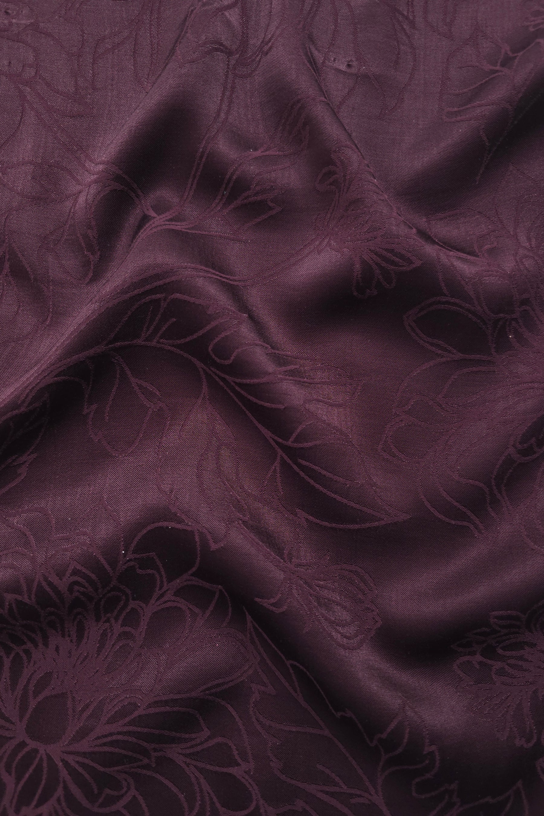 Floral tonal viscose jacquard fabric in a wave fold, showing silky sheen
