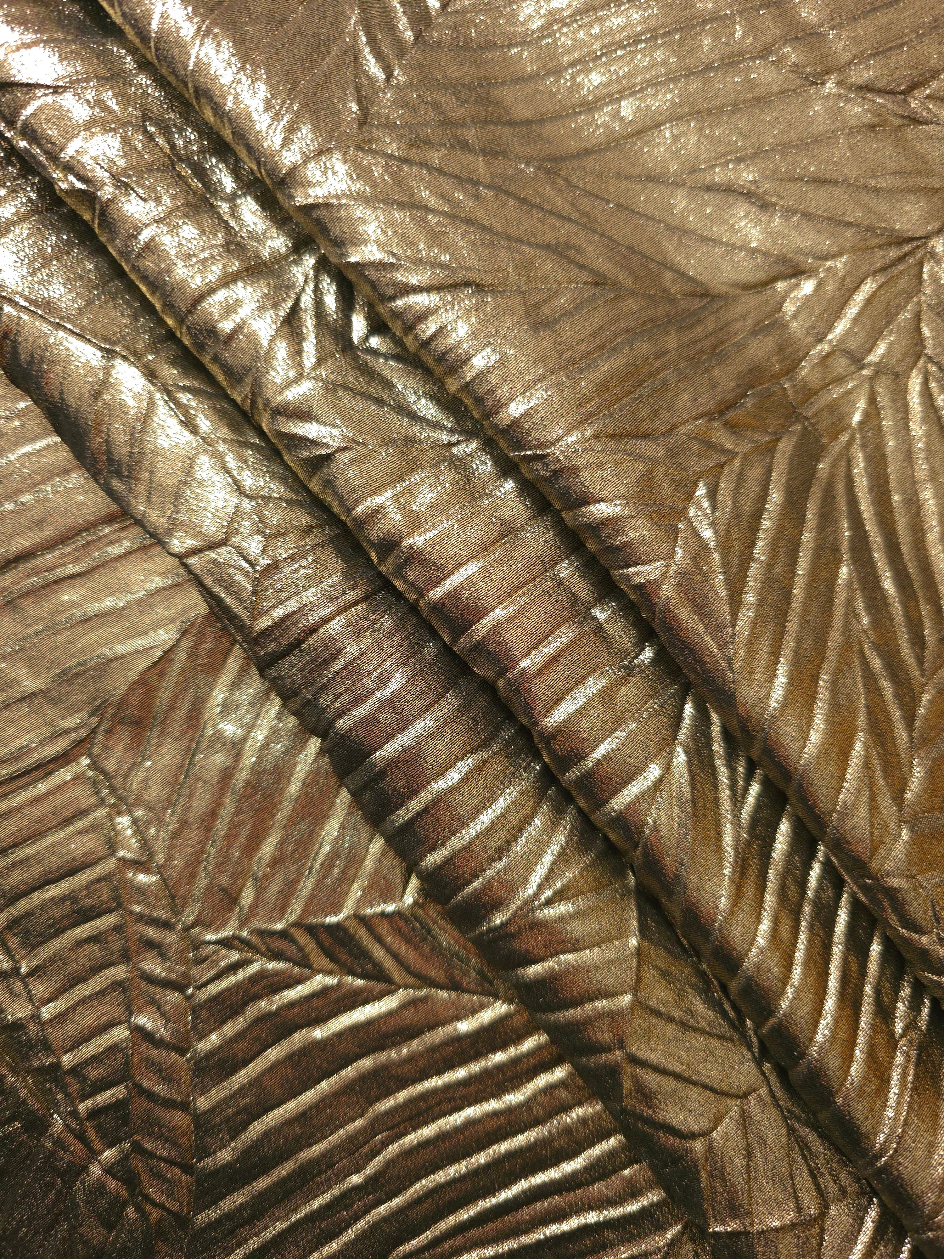 Antique Gold leaf-pattern plissé fabric in close detail, revealing the fine shimmer and dimensional pleat structure suited to bodice accents and fashion-forward blouses.