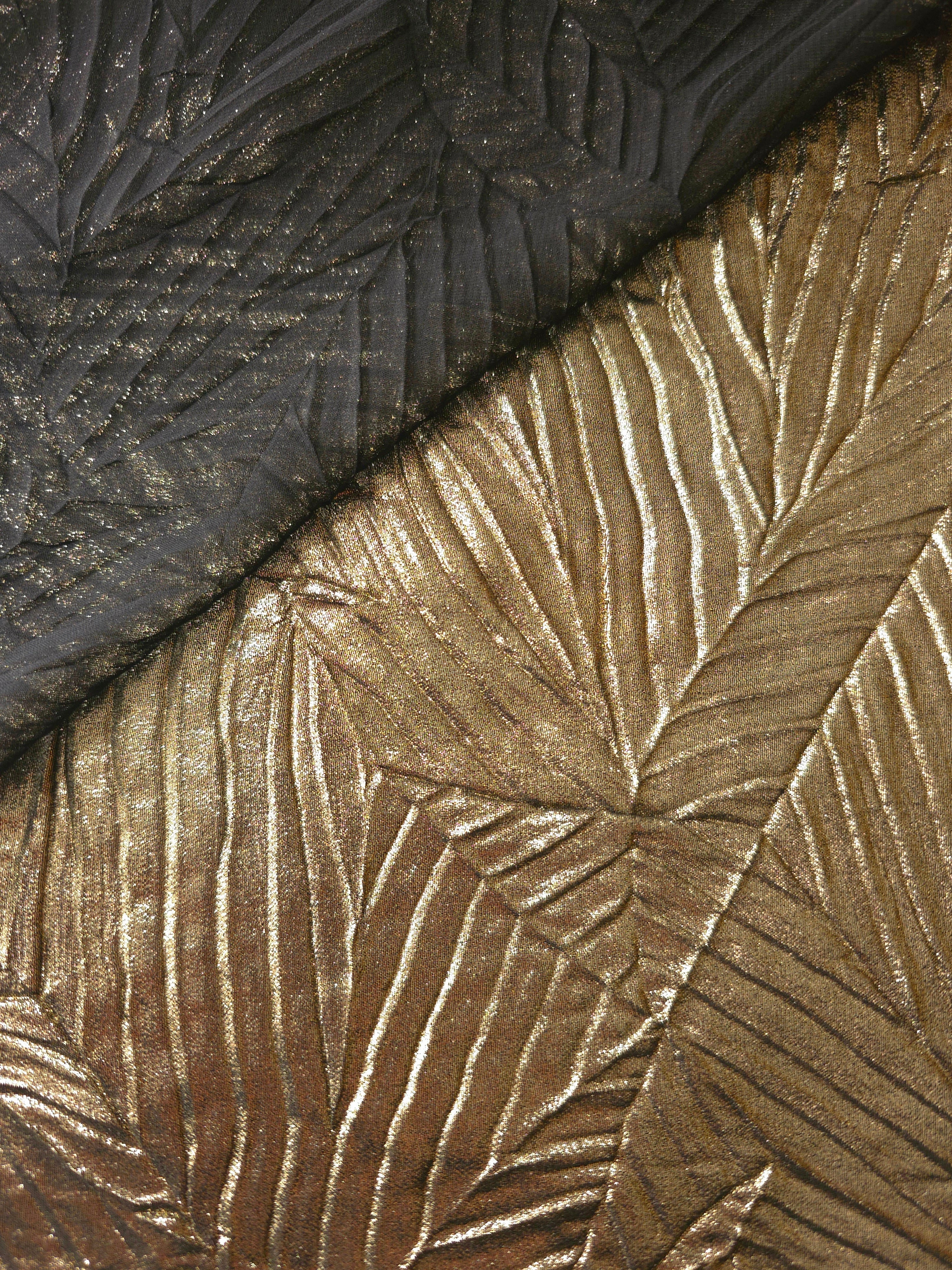 Fold detail of Antique Gold leaf-pattern plissé fabric demonstrates how the textured surface builds depth for stagewear and layered fashion details.