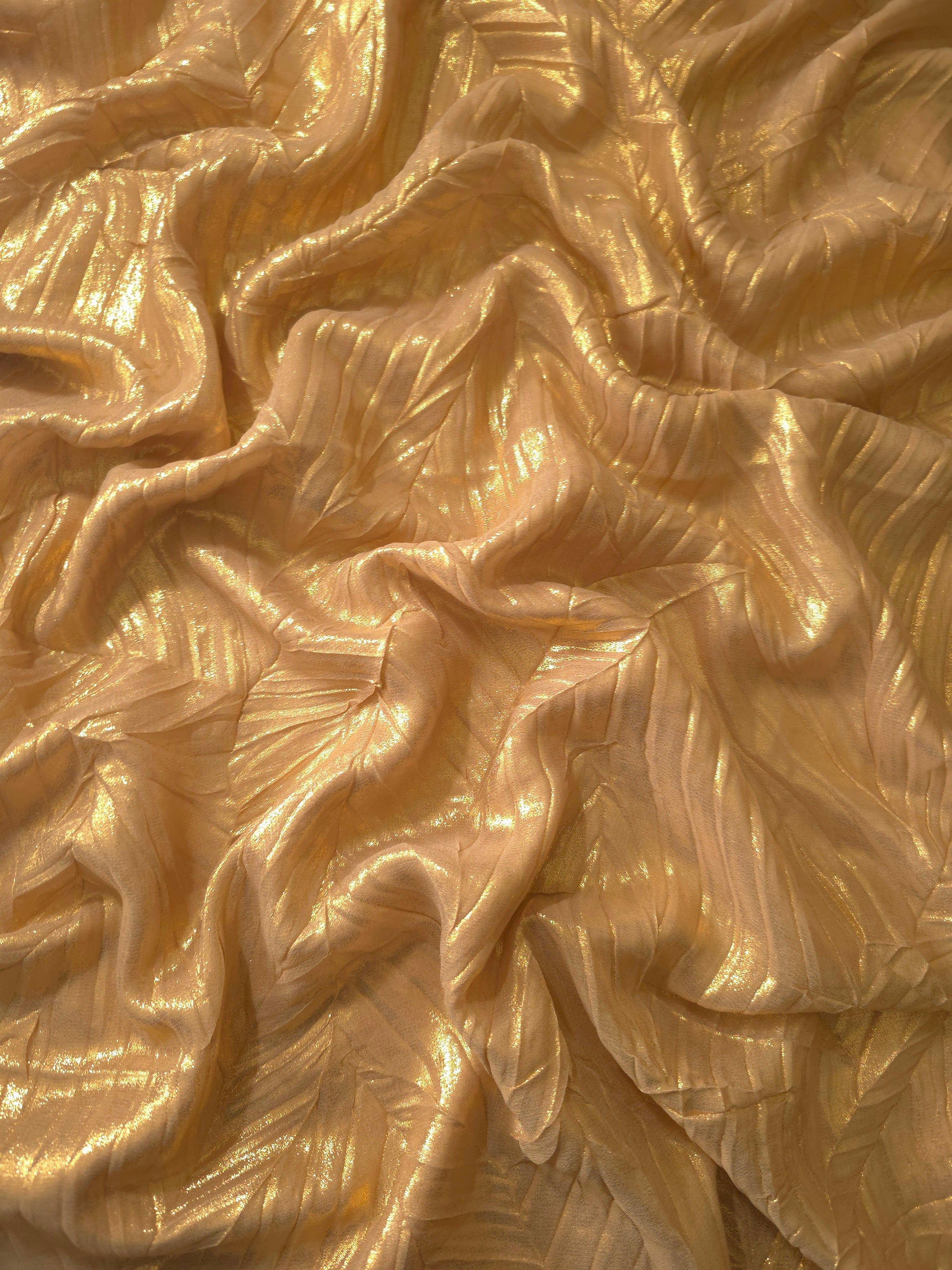 Flowing drape of Bronze Gold leaf-pattern plissé shimmer fabric, showing sculpted leaf-like pleats and light-catching movement for evening gowns and flowing maxi skirts.